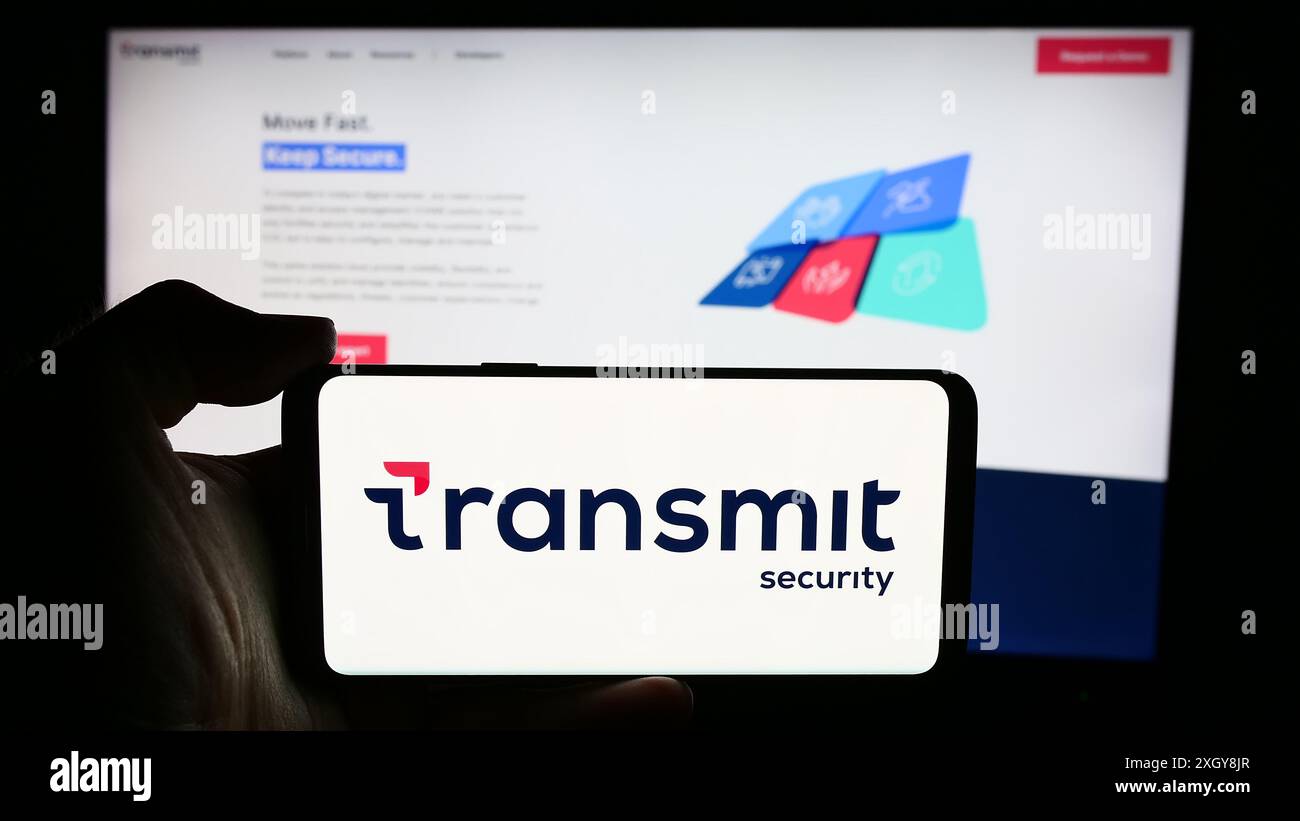 Personne tenant le téléphone portable avec le logo de la société de cybersécurité Transmit Security Inc devant la page Web de l'entreprise. Concentrez-vous sur l'affichage du téléphone. Banque D'Images