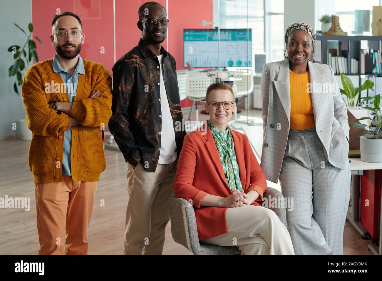 Groupe de collègues divers posant avec confiance dans le bureau moderne. Comprend des membres caucasiens, noirs et multiraciaux, soulignant le travail d'équipe et la diversité Banque D'Images