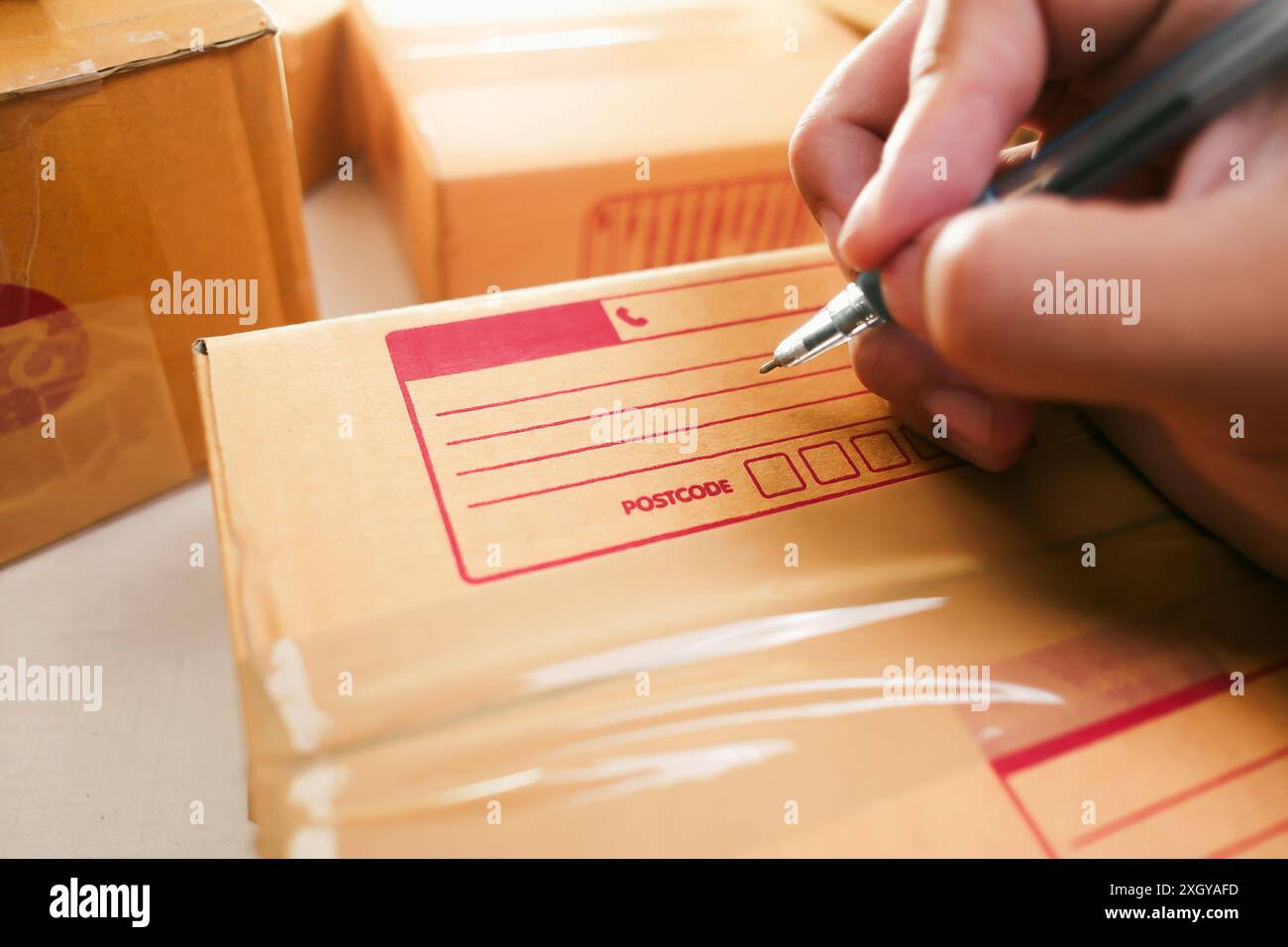 Concept de livraison de marchandises Human Hand écrit une adresse sur une boîte en carton pour la livraison à un client Banque D'Images