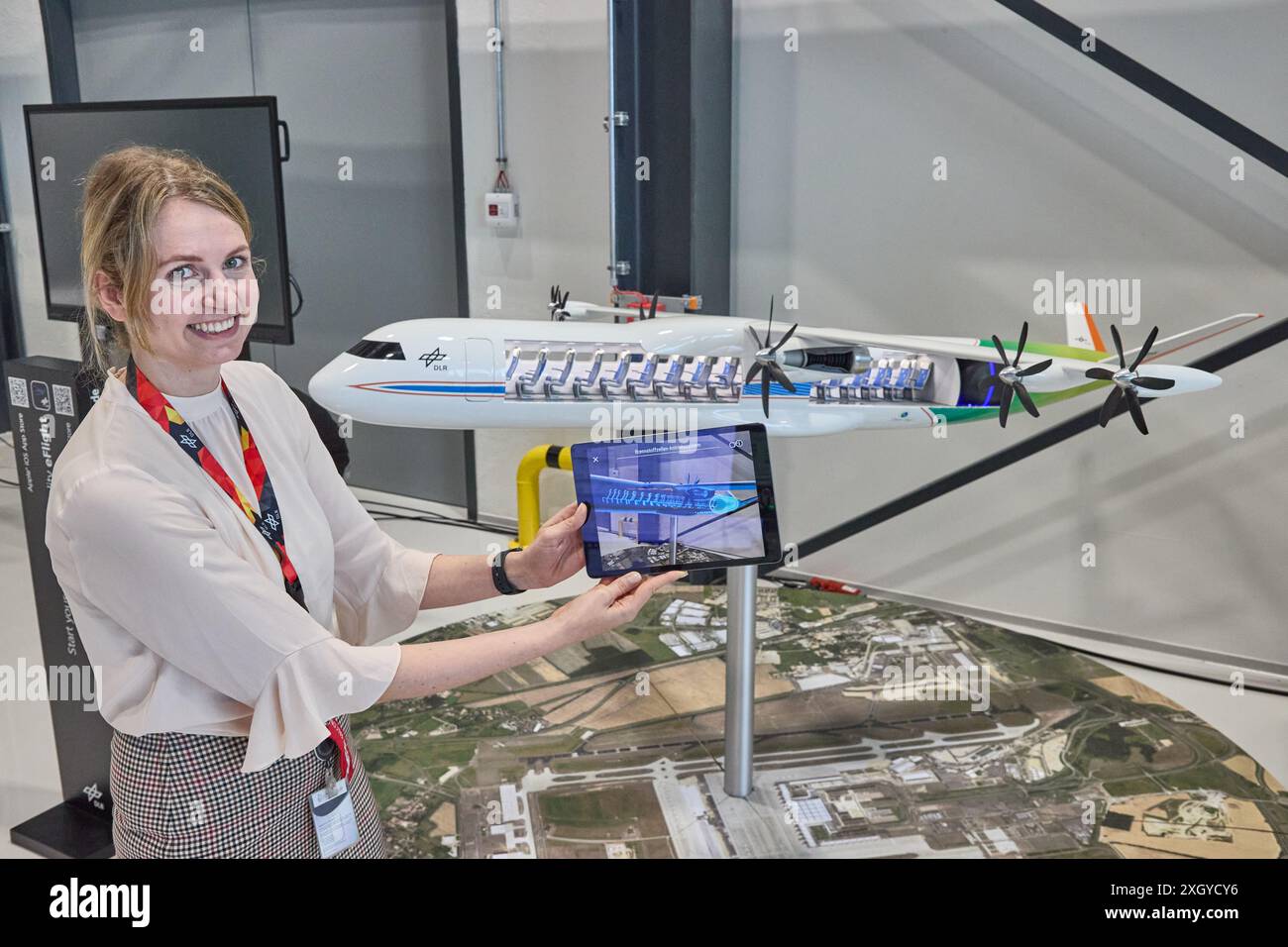 Hambourg, Allemagne. 10 juillet 2024. Mara Fuchs, Group leader du Centre aérospatial allemand (DLR) - Institut d'architecture des systèmes en aéronautique, montre l'intégration du système de propulsion à pile à combustible d'un avion avec les technologies de l'hydrogène sur une tablette lors de l'inauguration de l'extension du Centre ZAL de recherche aéronautique appliquée. Crédit : Georg Wendt/dpa/Alamy Live News Banque D'Images