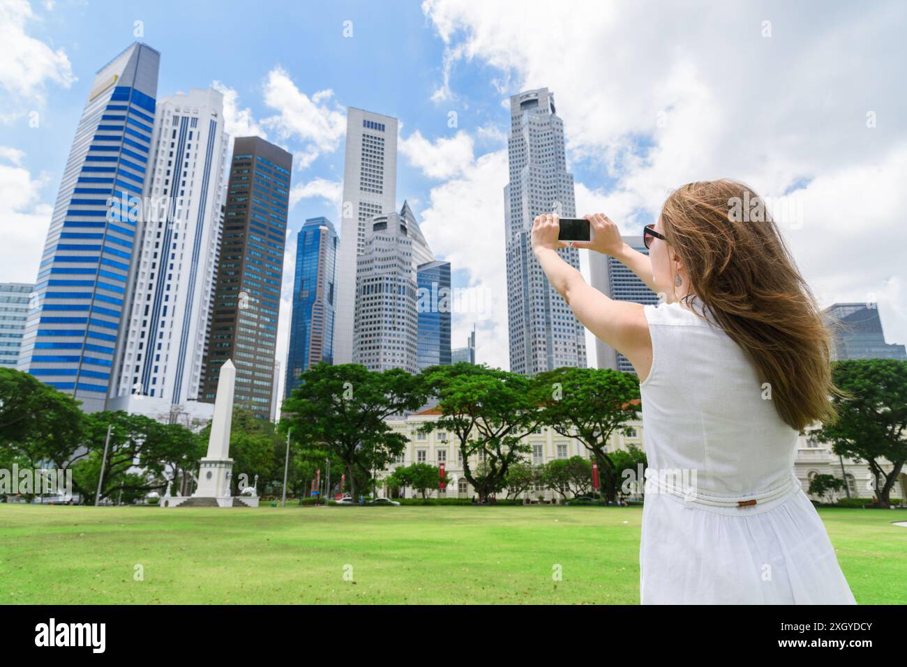 Fille avec un smartphone prenant une photo de paysage urbain incroyable dans le centre de Singapour. Banque D'Images