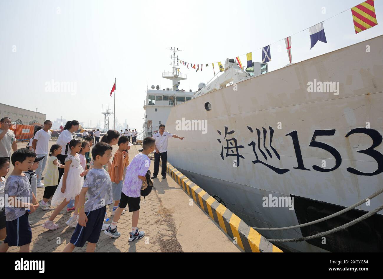 YANTAI, CHINE - 11 JUILLET 2024 - les enfants sont guidés par un membre d'équipage pour visiter le navire de navigation Haixun 153 au phare de navigation de Yantai Off Banque D'Images