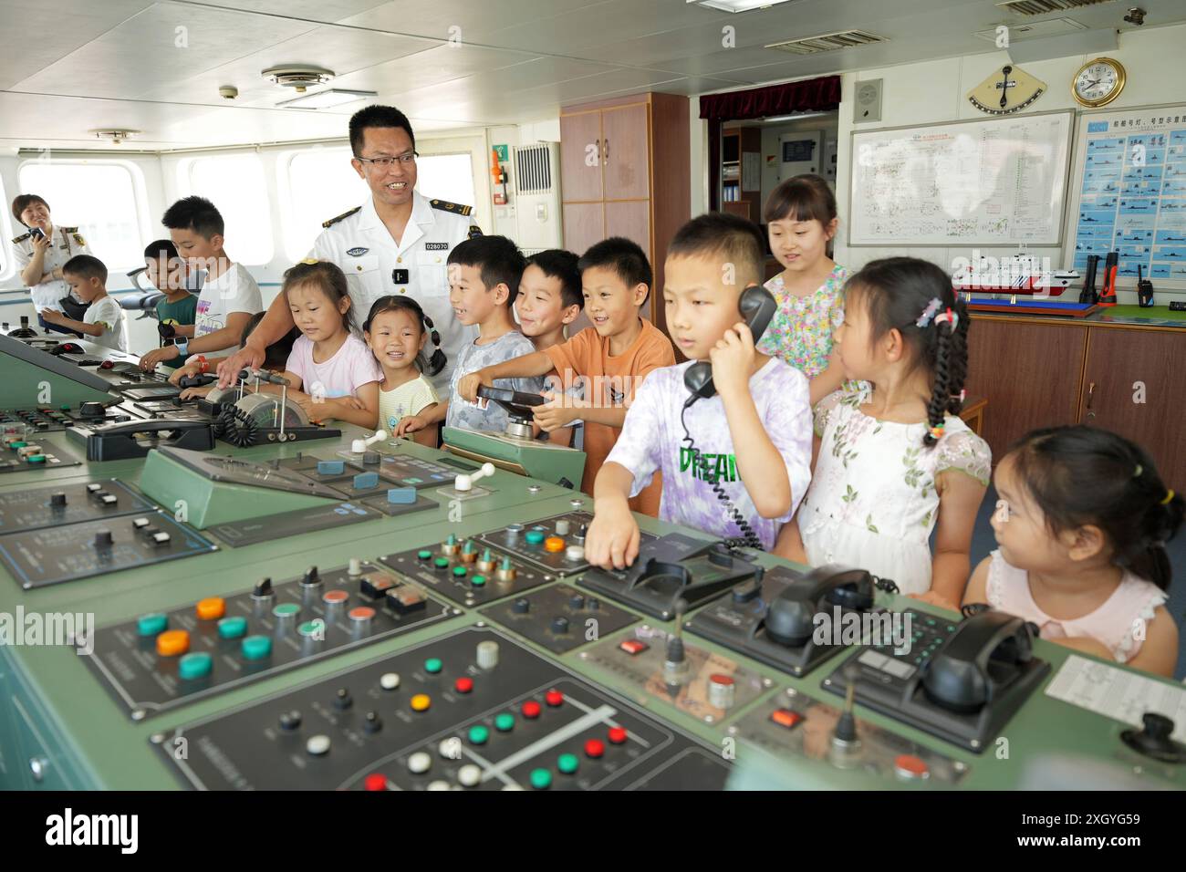 YANTAI, CHINE - 11 JUILLET 2024 - Un membre d'équipage du navire de navigation 'Haixun 153' présente les connaissances de la voile aux enfants du Yantai Navigatio Banque D'Images