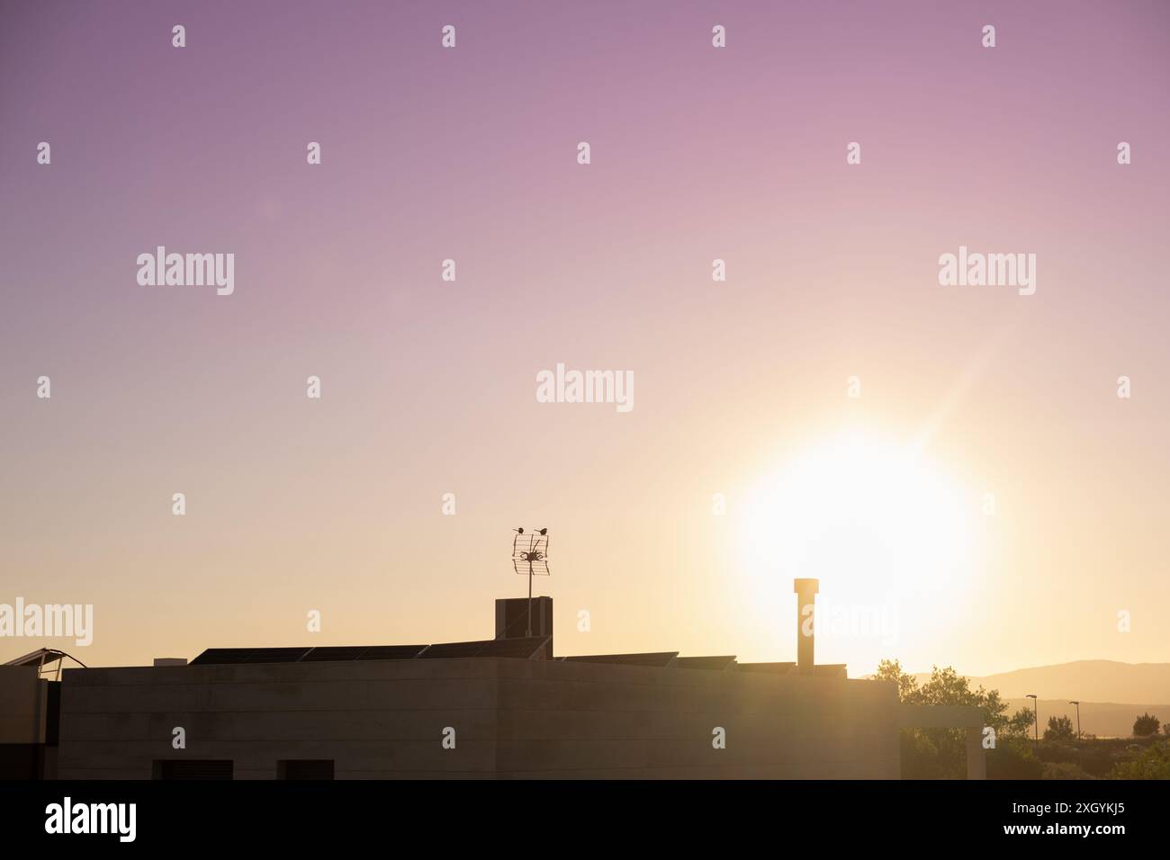 Certaines maisons modernes ont des panneaux solaires photovoltaïques avec un coucher de soleil en arrière-plan. Le concept d'économiser l'énergie et de prendre soin de la planète Banque D'Images