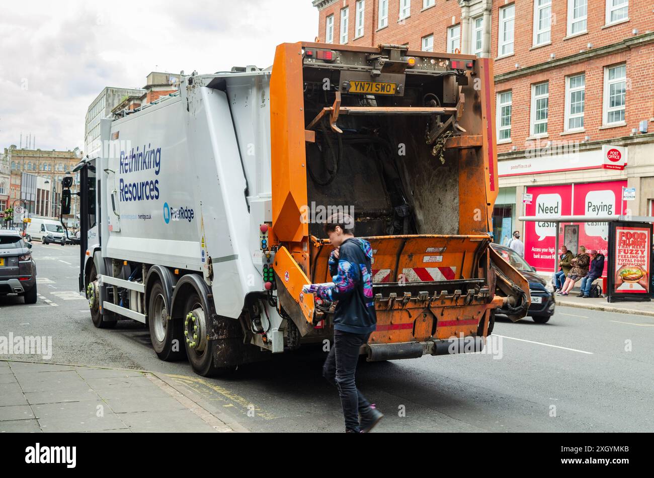 Belfast , Comté d'Antrim Irlande du Nord 05 juillet 2024 -camion de collecte de poubelle dans la rue élevée Belfast avec l'homme marchant devant Banque D'Images