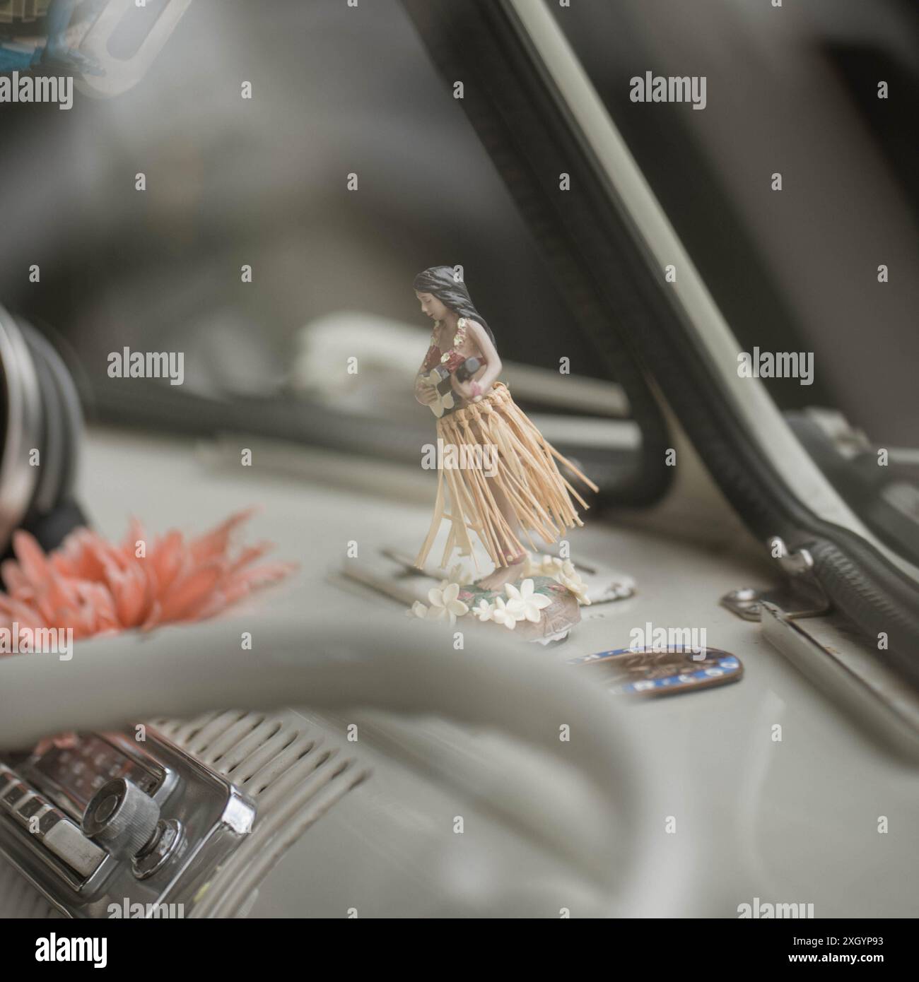 Un ornement de tableau de bord Hawaaiian Hula Girl sur le tableau de bord d'un bus VW à écran partagé classique Banque D'Images
