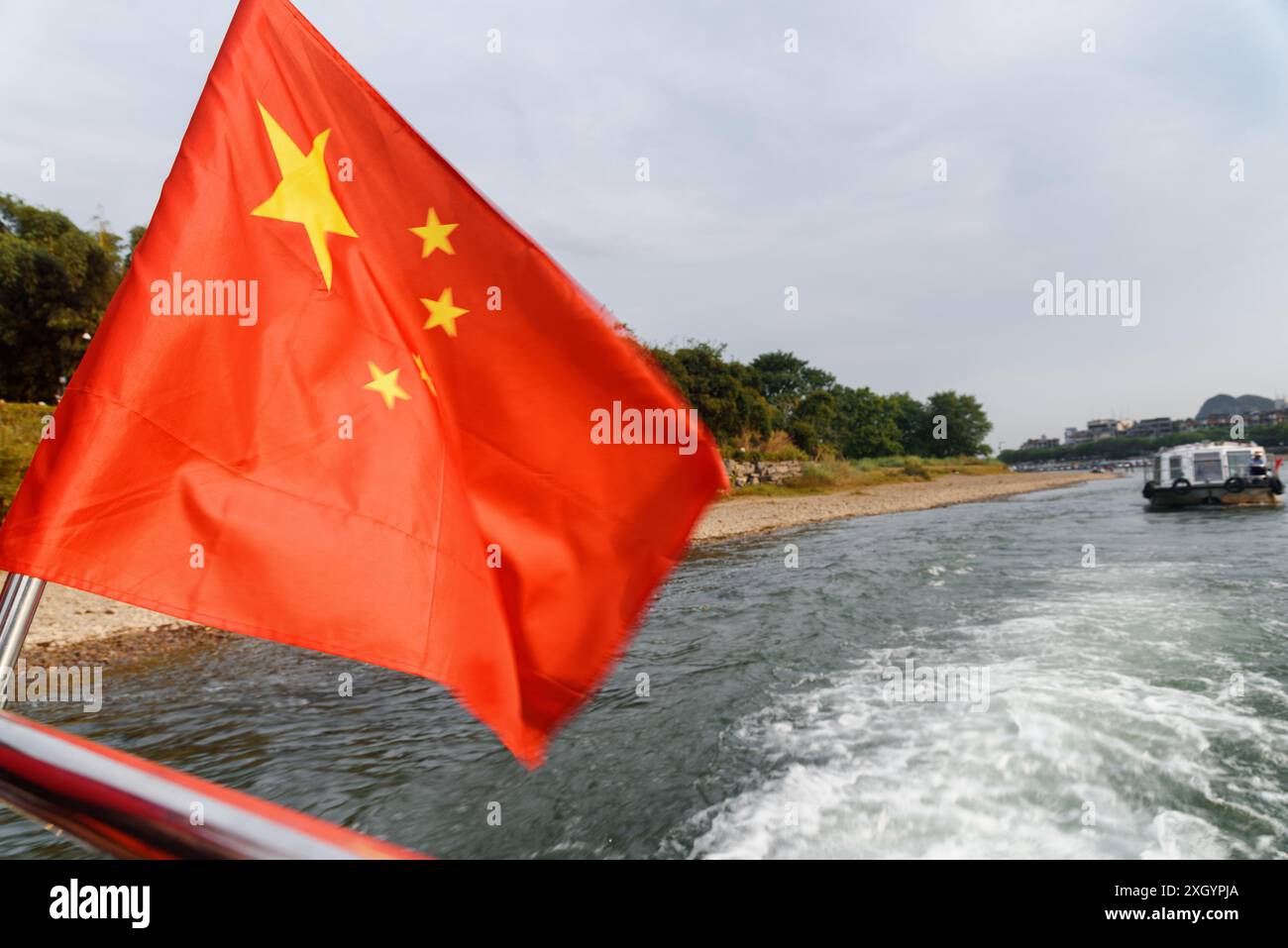 Le drapeau de la République populaire de Chine (le drapeau rouge cinq étoiles) flottant sur un bateau naviguant sur la rivière Li (rivière Lijiang) au centre-ville de Guilin Banque D'Images