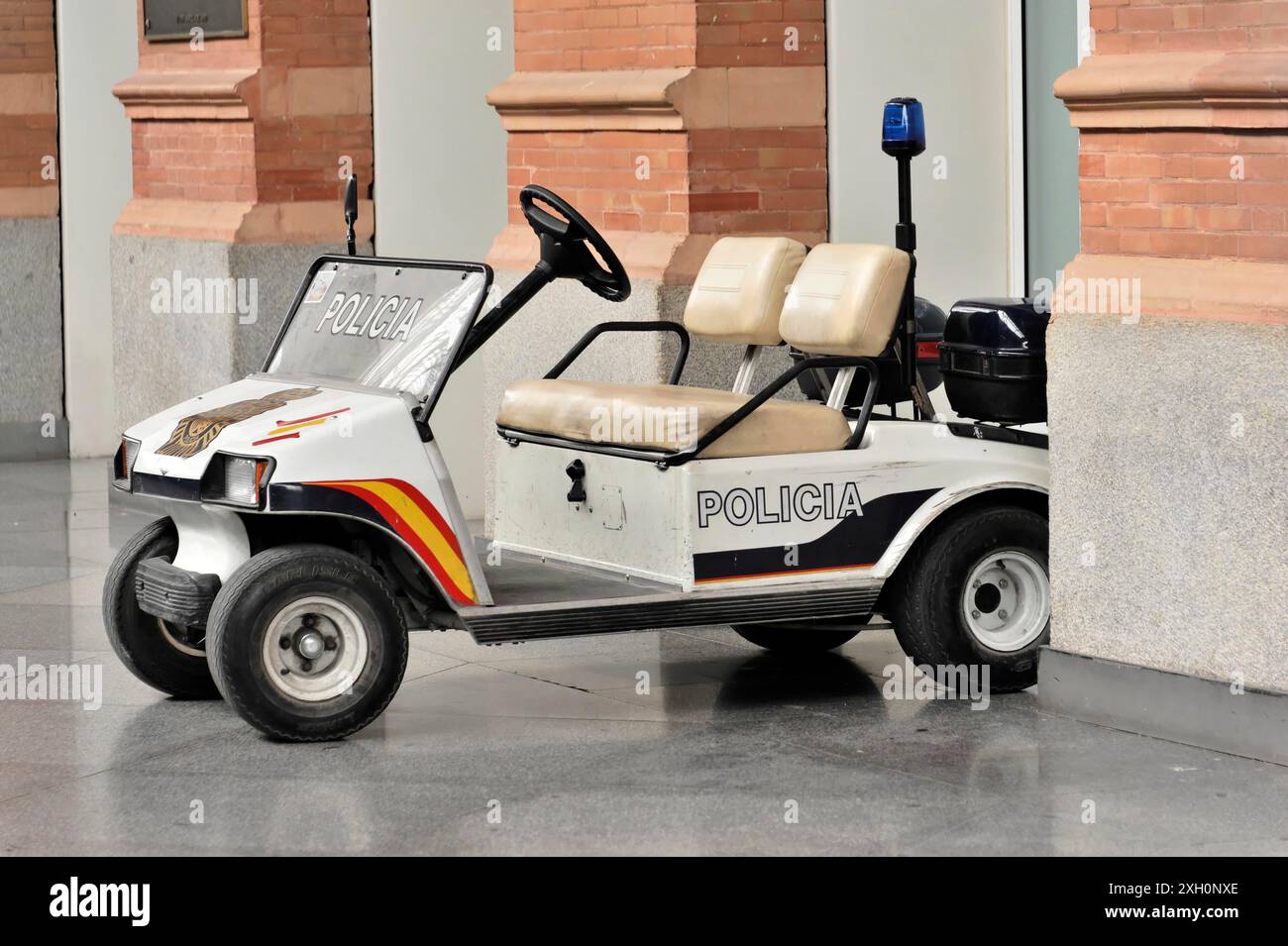 Voiture de police à la gare d'Atocha, Madrid, Espagne, Europe, petite voiture de police blanche debout au bord d'un bâtiment avec des murs de briques Banque D'Images