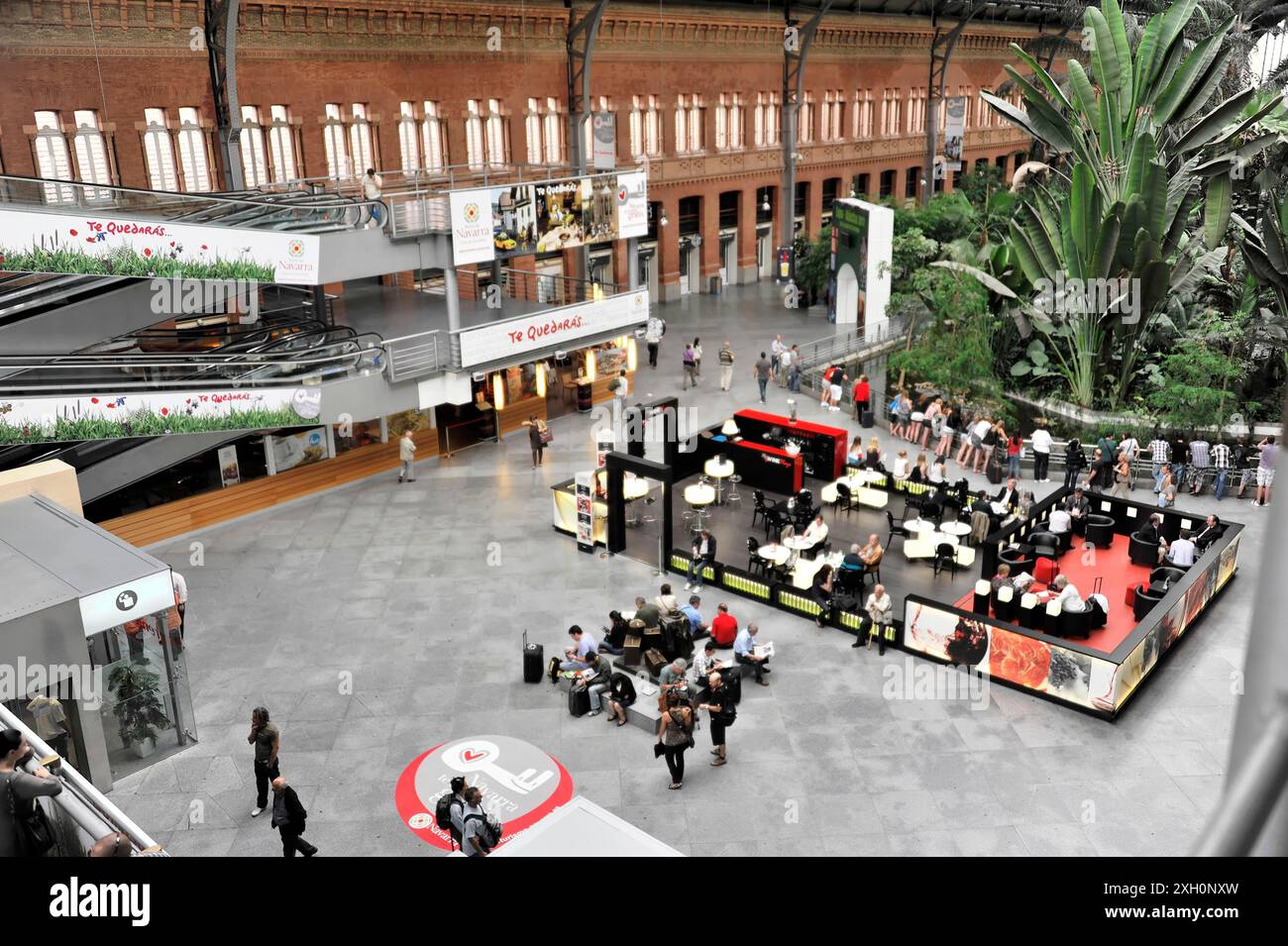Gare d'Atocha, Madrid, Espagne, Europe, grand hall de gare avec des gens, des coins salon et des magasins, entouré de plantes Banque D'Images