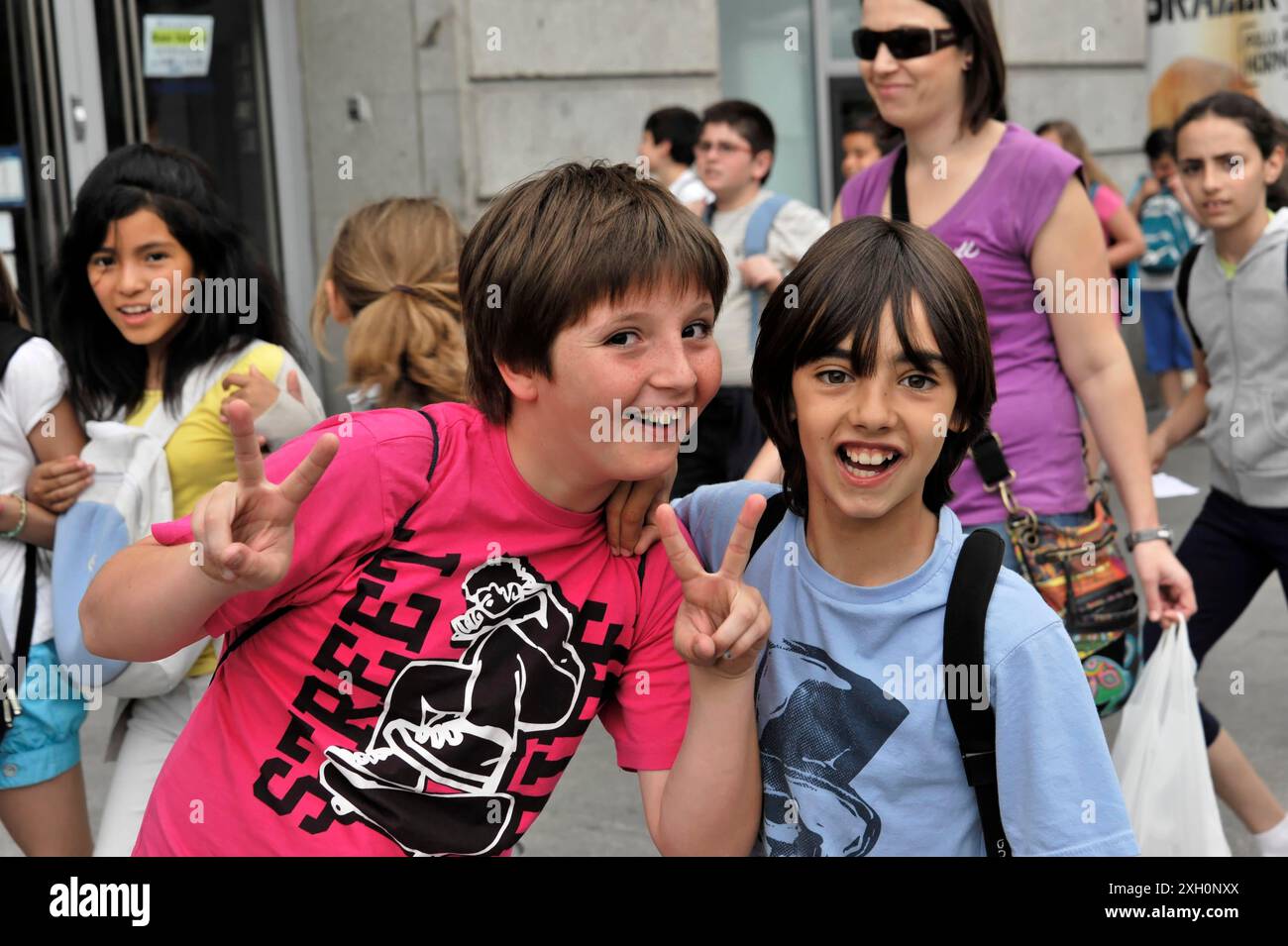 Madrid, Espagne, Europe, deux enfants souriants et montrant le signe de la paix dans une rue de la ville Banque D'Images