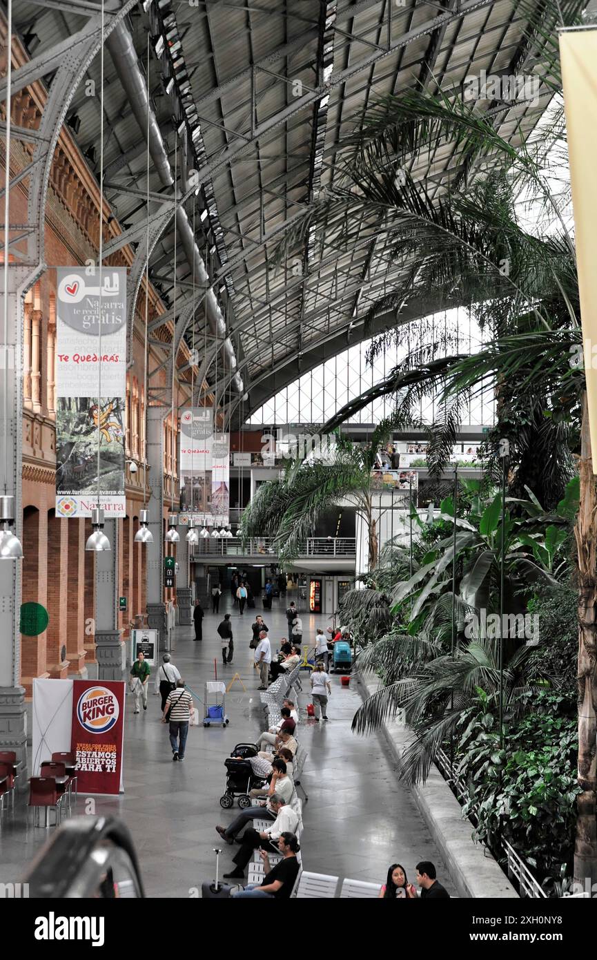 Gare d'Atocha, Madrid, Espagne, Europe, hall de la gare avec un haut toit en verre, les gens marchant et les palmiers obscurcissant partiellement la vue Banque D'Images