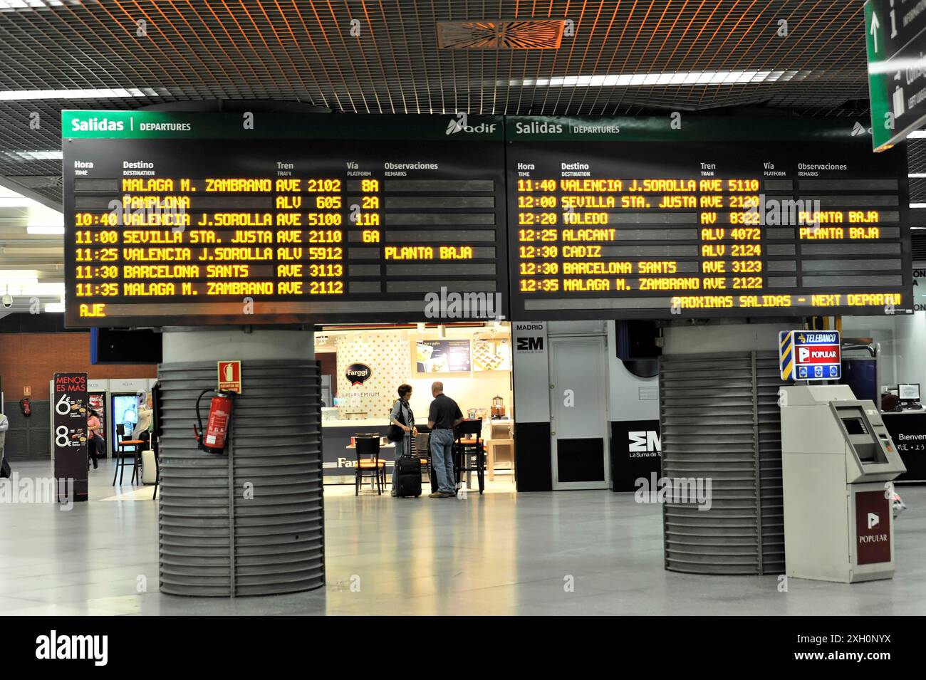 Gare d'Atocha, Madrid, Espagne, Europe, le tableau de départ numérique montre les heures de départ et les numéros de quai, quelques voyageurs en arrière-plan Banque D'Images