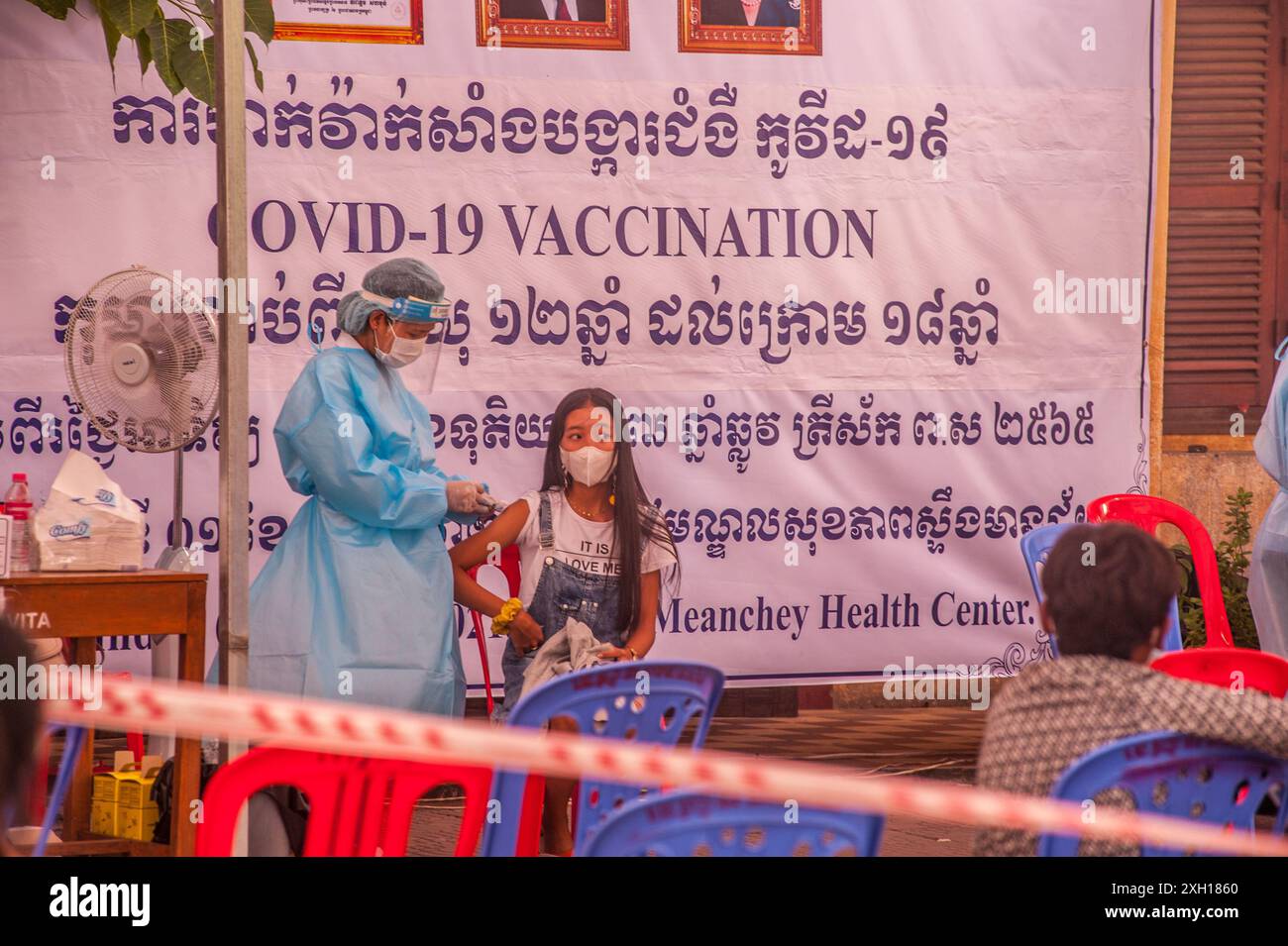 Une adolescente reçoit sa vaccination COVID-19 sur un site d'inoculation de masse. Stueng Meanchey, Phnom Penh, Cambodge. Le 4 septembre 2021. © Kraig Lieb Banque D'Images