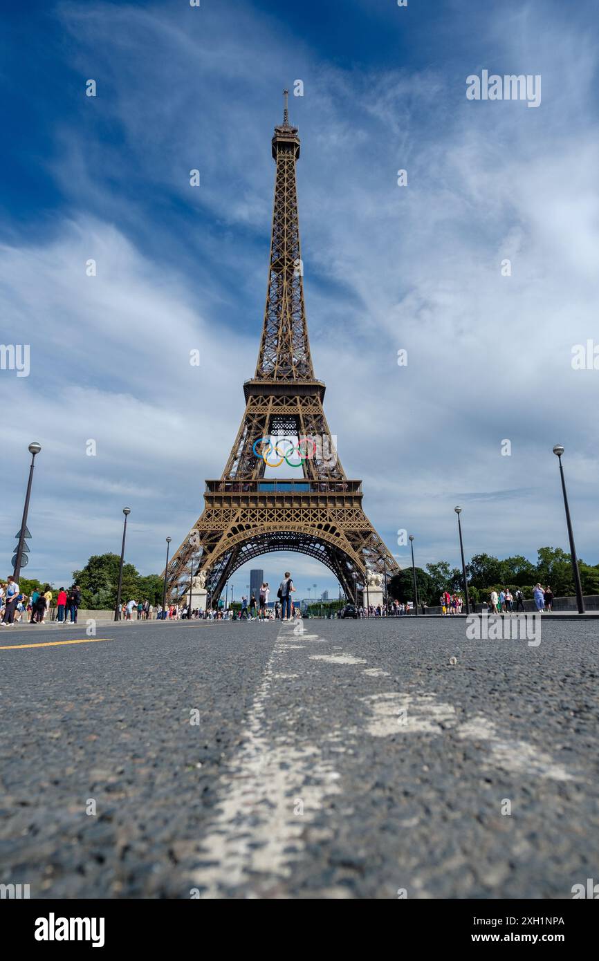 Paris, France - 5 juillet 2024 : vue panoramique des touristes marchant sous la majestueuse Tour Eiffel décorée des anneaux olympiques à Paris France Banque D'Images