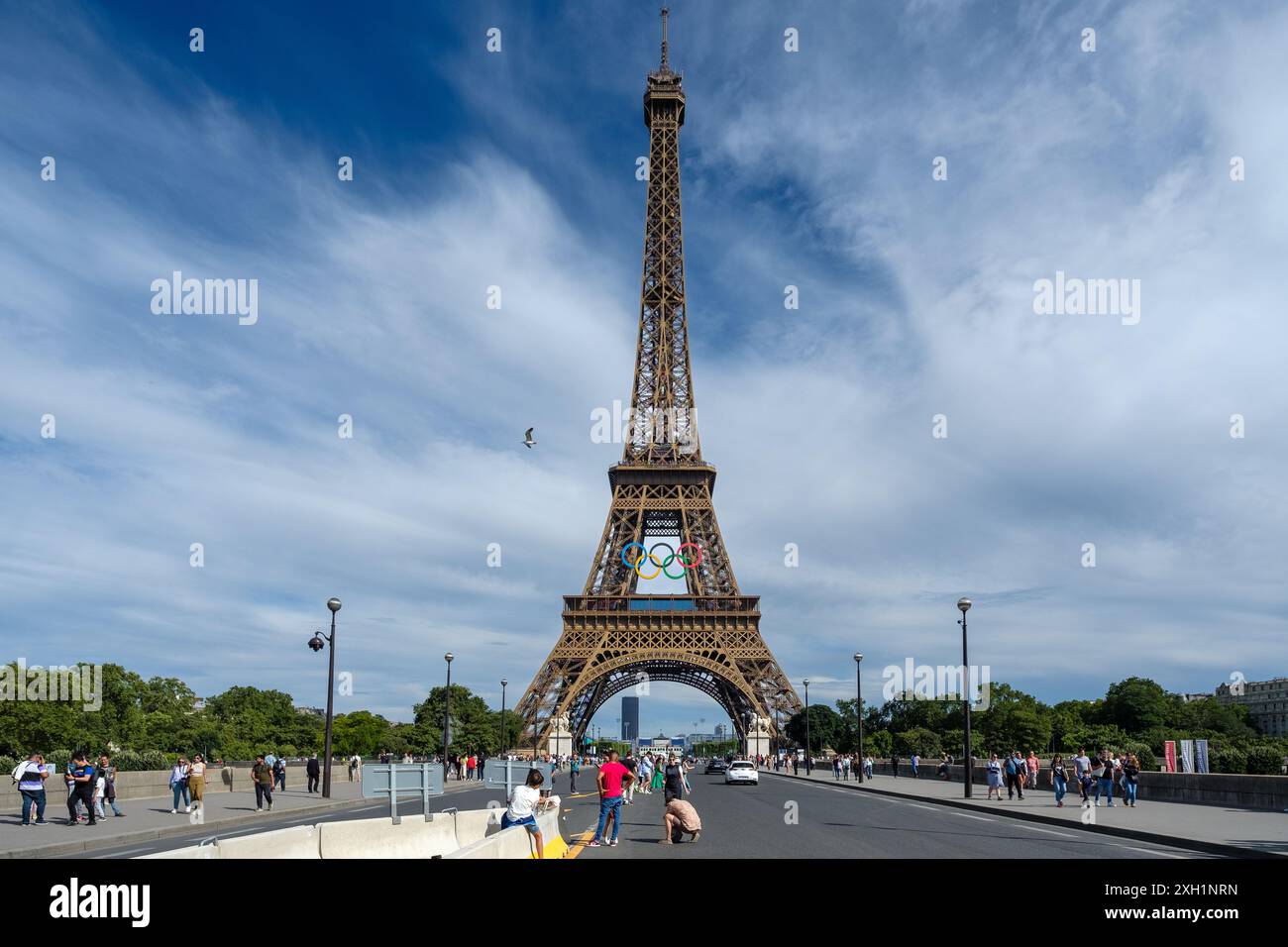 Paris, France - 5 juillet 2024 : vue panoramique des touristes marchant sous la majestueuse Tour Eiffel décorée des anneaux olympiques à Paris France Banque D'Images