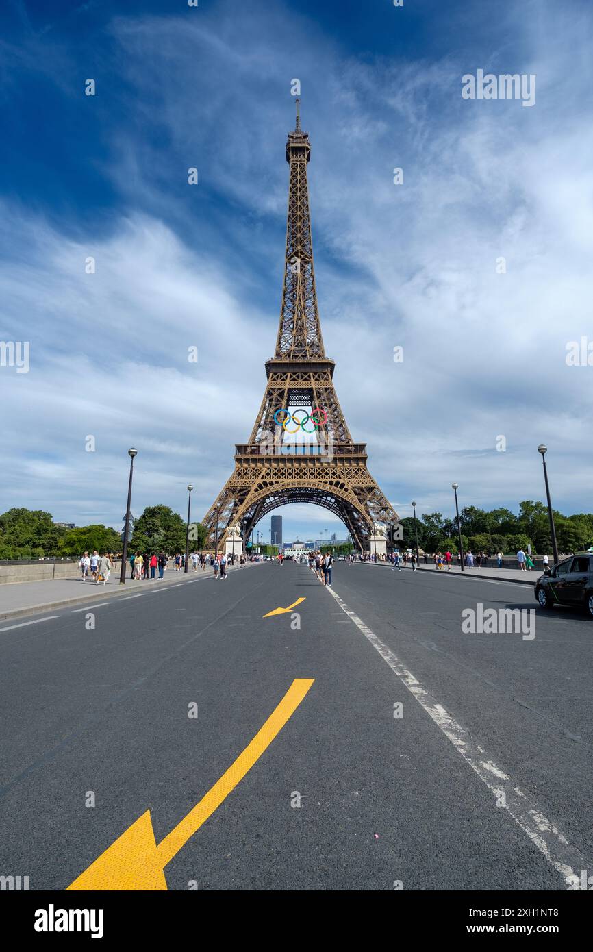 Paris, France - 5 juillet 2024 : vue panoramique des touristes marchant sous la majestueuse Tour Eiffel décorée des anneaux olympiques à Paris France Banque D'Images
