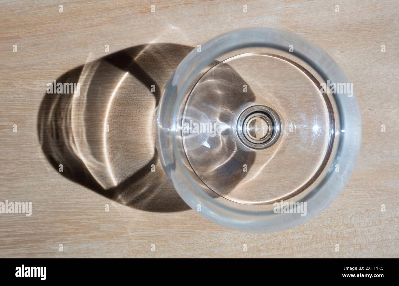 Vin ou verre à grenaille vu de dessus, éclairé par le soleil, avec ombre sur fond de bois Banque D'Images