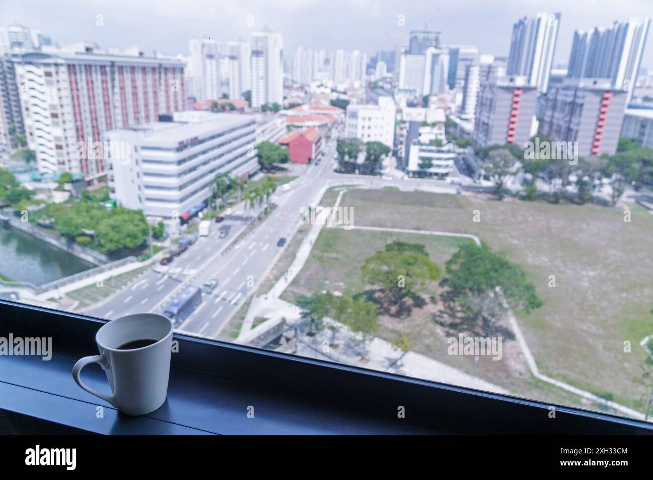 11 octobre 2019, Singapour, Asie du Sud-est : tasse de café à côté d'une fenêtre dans un hôtel avec vue sur la ville. Banque D'Images