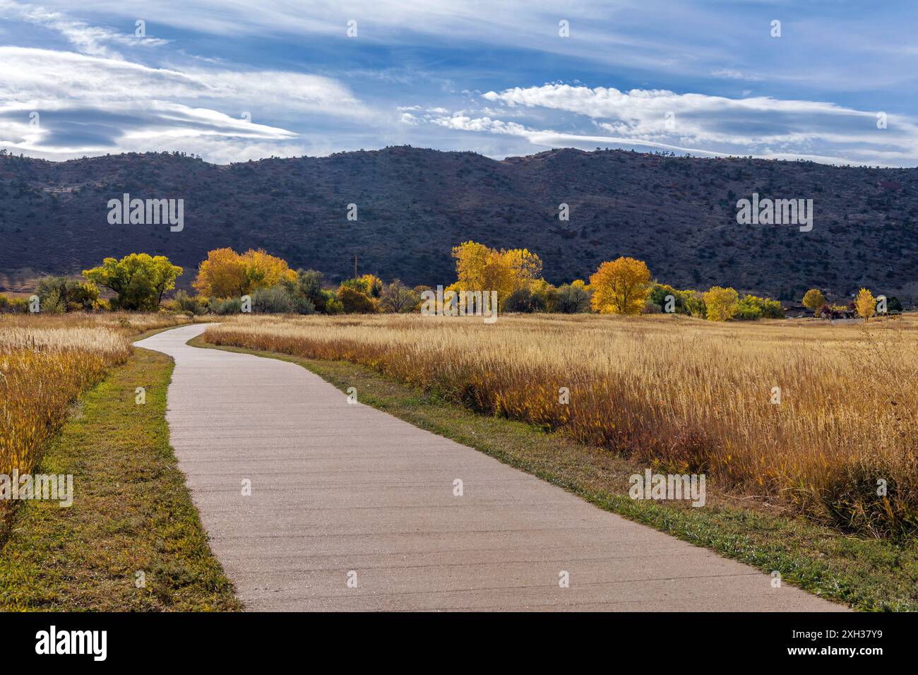 Autumn Mountain Park - Une journée d'automne ensoleillée vue d'un sentier de vélo et de randonnée sinueux à Bear Creek Lake Park, Denver-Lakewood, Colorado, États-Unis. Banque D'Images