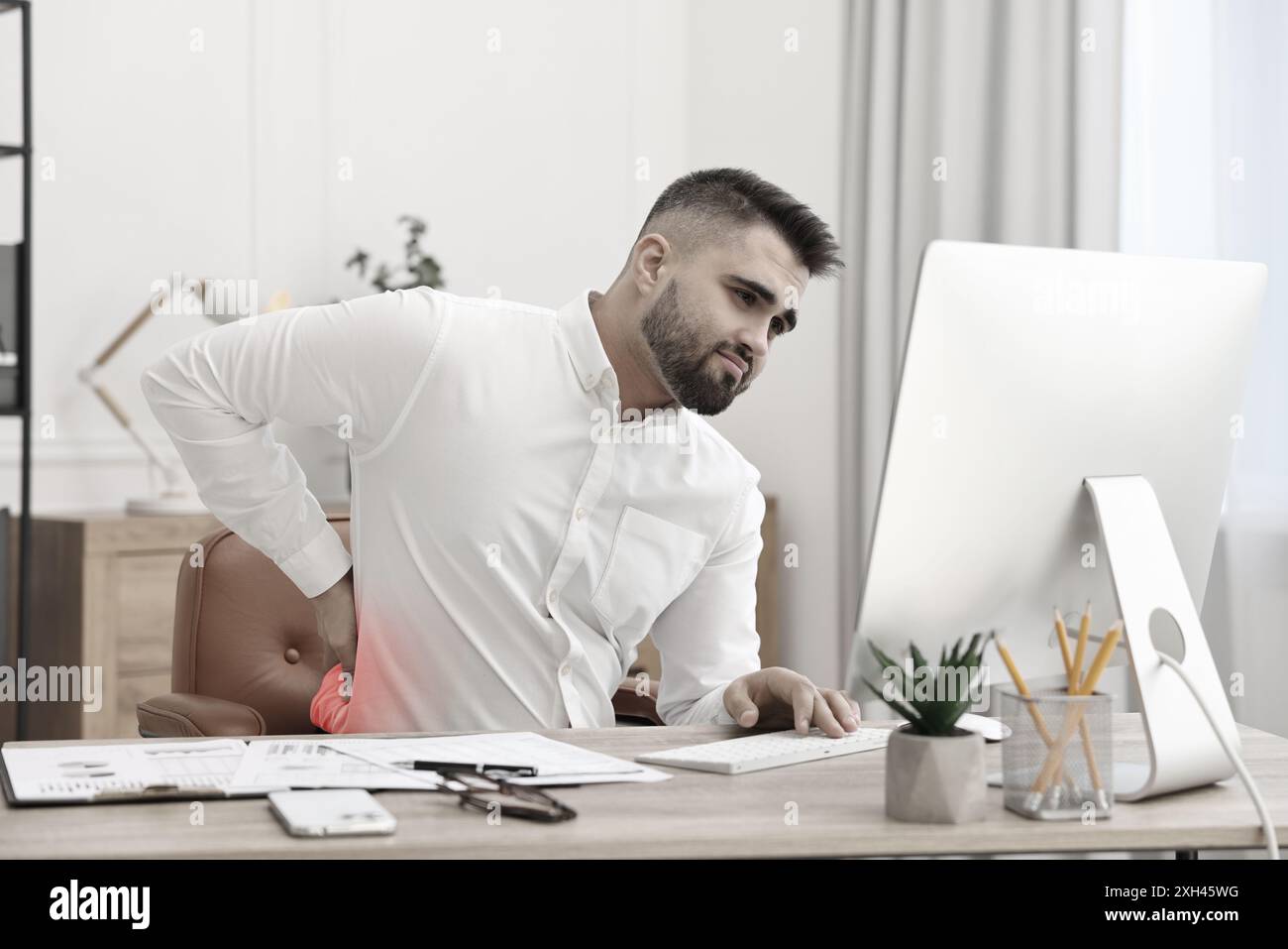 Homme souffrant de mal de dos dû à une mauvaise posture au travail Banque D'Images