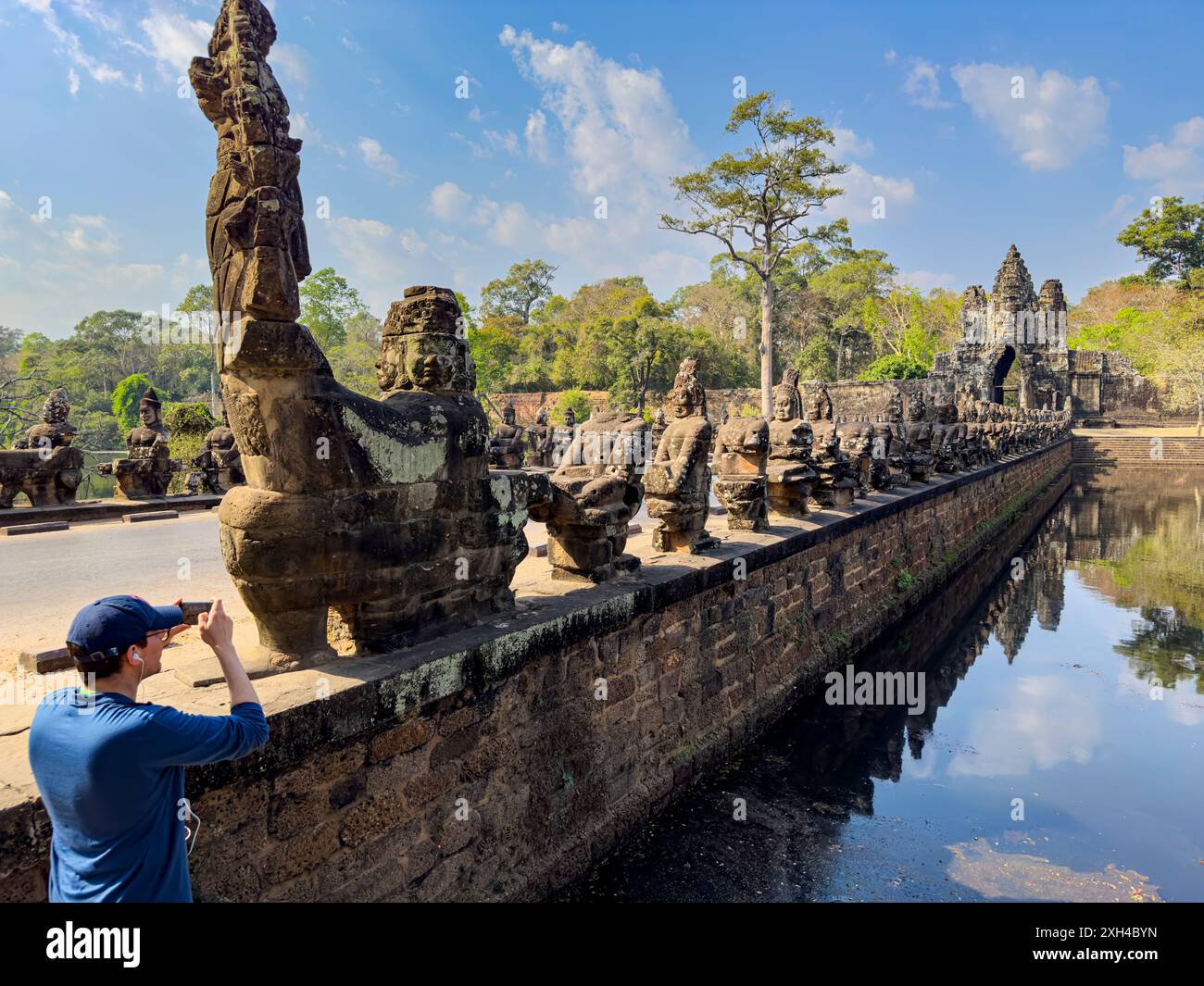 Le pont vers Angkor Thom, bordé des deux côtés de figurines se terminant par une entrée en arc encorbée, Cambodge. Banque D'Images Le pont vers Angkor Thom, bordé des deux côtés de figurines se terminant par une entrée en arc encorbée, Cambodge. Banque D'Images