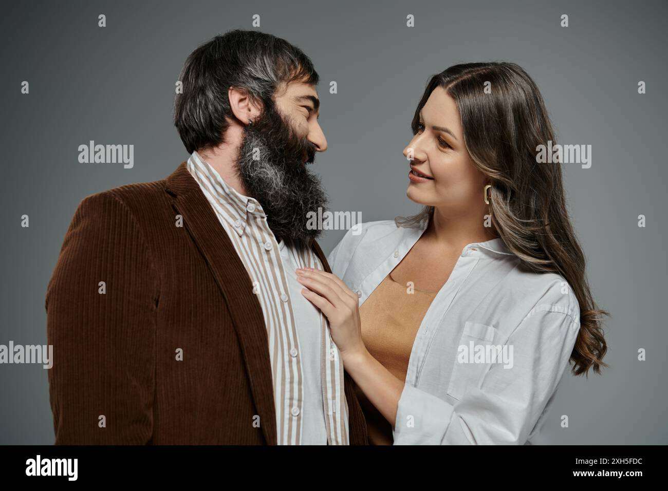 Un homme barbu et une femme en tenue élégante se regardent amoureusement. Banque D'Images