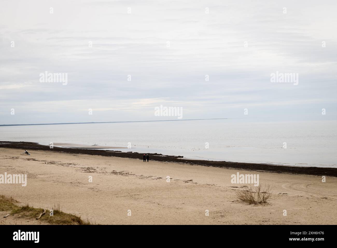 JURMALA, LETTONIE. 8 avril 2024. Eau calme en mer. Les gens font une promenade près du bord de mer. Banque D'Images