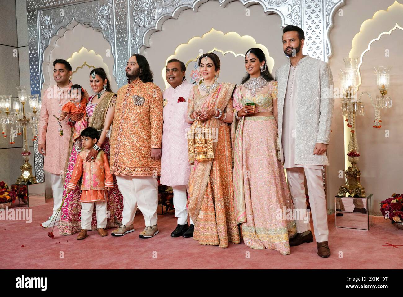 Billionaire Mukesh Ambani, center, poses for a photograph with his family members from L to R, son Akash, daughter-in-law Shloka, son Anant, wife Nita, daughter Isha and son-in-law Anand Piramal at the wedding of his son Anant Ambani and Radhika Merchant at Jio World Convention Centre in Mumbai, India, Friday, July 12, 2024. (AP Photo /Rajanish Kakade) Banque D'Images