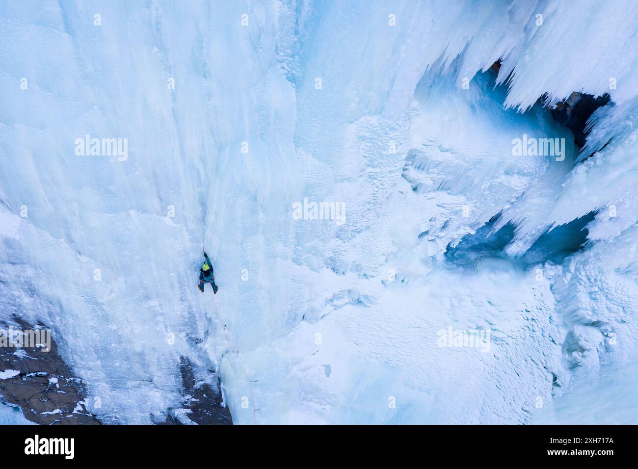 L'homme mène sur la glace. Escalade de glace sur la cascade gelée, vue aérienne. Vallée de Barskoon, Kirghizistan. Banque D'Images