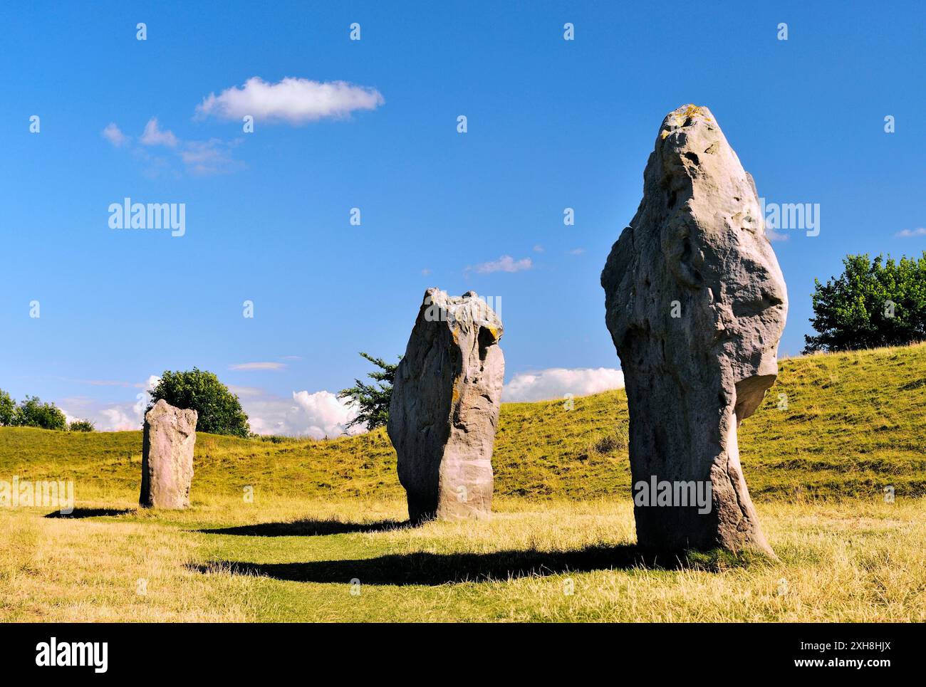 Avebury henge néolithique et de cercles de pierres, Wiltshire, Angleterre. Banque Henge derrière 3 mégalithes du cercle extérieur. 5600 ans Banque D'Images