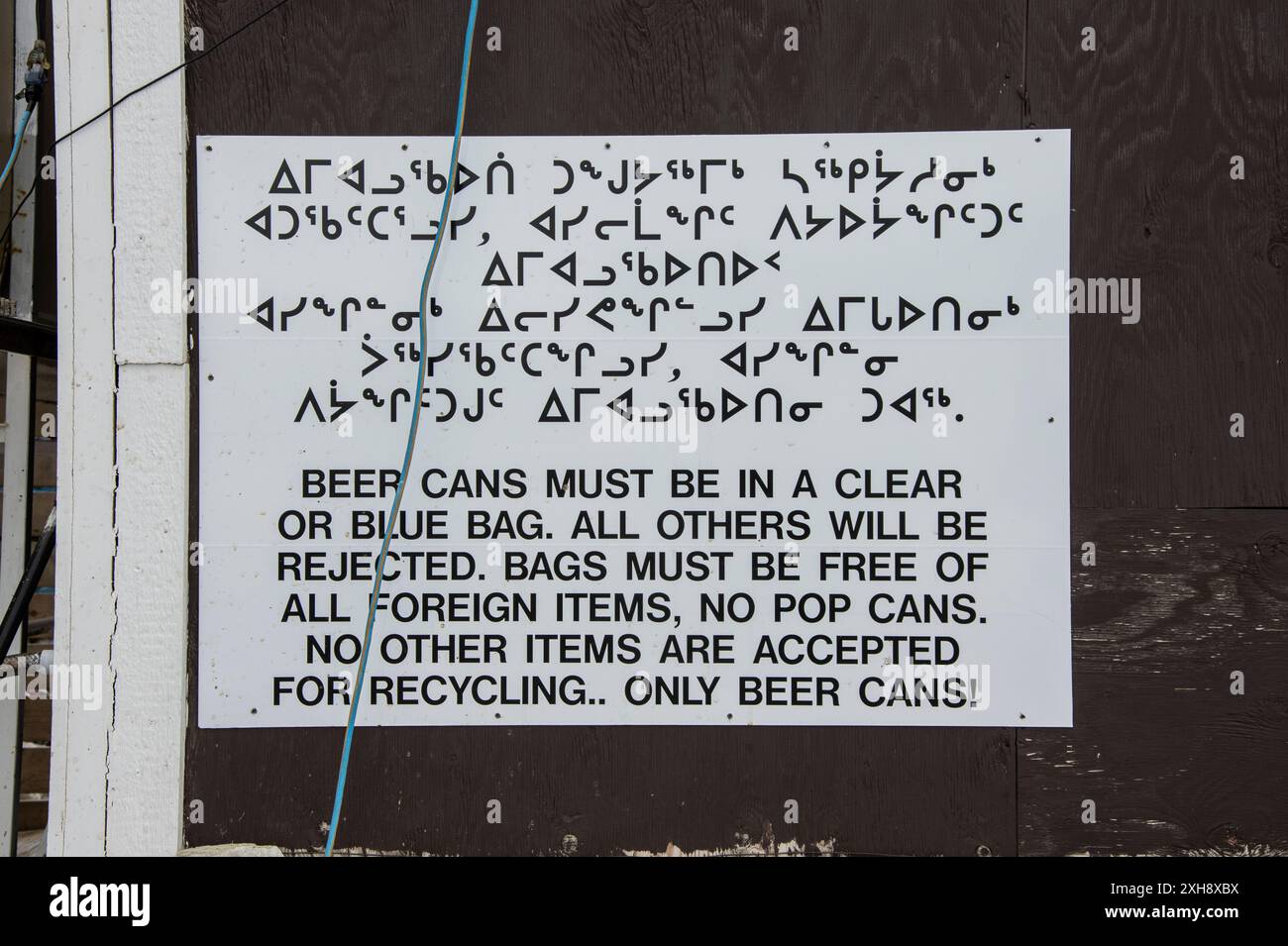 Panneau d'instruction bilingue sur l'ensachage de canettes de bière en anglais et en inuktitut à Northern Collectibles sur Ulu Lane à Iqaluit, Nunavut, Canada Banque D'Images