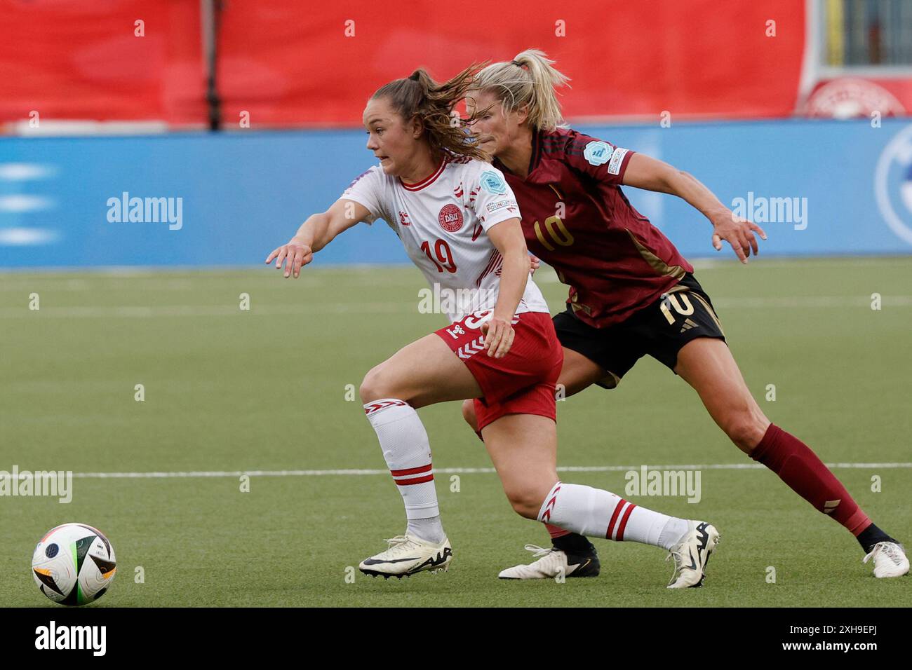 Denmark's Janni Thomsen, left, fights for the ball against Belgium's Justine Vanhaevermaet during the Euro 2025, league A, group A2 qualifying soccer match between Belgium and Denmark at the Stayen stadium in Sint-Truiden, Belgium, Friday, July 12, 2024. (AP Photo/Omar Havana) Banque D'Images