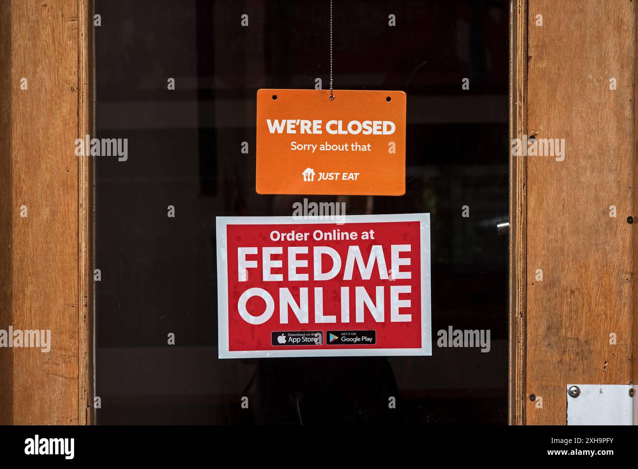 Nous sommes un signe fermé sur la porte d'un café avec un signe Feed me Online ci-dessous à Édimbourg, Écosse, Royaume-Uni. Banque D'Images