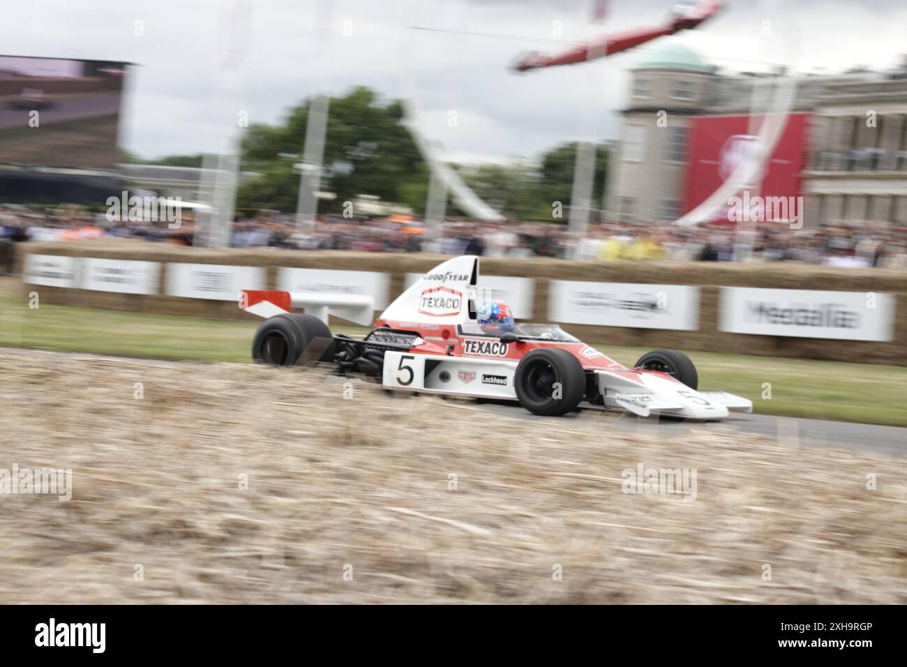 Goodwood House, West Sussex, Royaume-Uni. , . Le festival annuel de vitesse de Goodwood, qui se tient à la maison ancestrale du 11e duc de RichmondÕs, Goodwood House. Ici : Emerson Fittipaldi crie devant la maison principale dans sa McLaren M23 crédit : Motofoto/Alamy Live News Banque D'Images