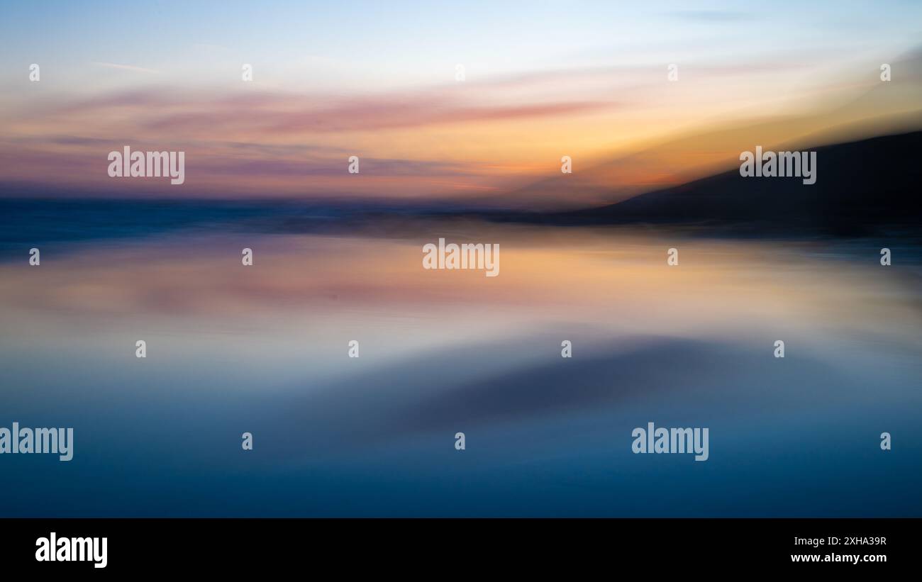 Mouvement intentionnel de la caméra, ICM, coucher de soleil, falaises, réflexion de la mer et de la plage Banque D'Images