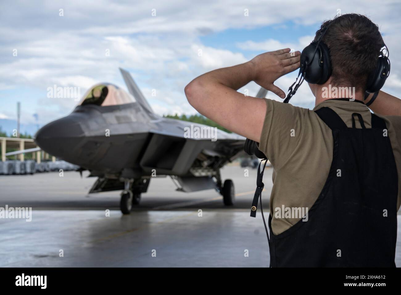 Mirsad Beganovic, un aviateur de 1re classe de l’US Air Force, chef d’équipage affecté au 525e Escadron de la génération de chasseurs, marshale un F-22 Raptor piloté par le colonel Kevin Jamieson après le dernier vol de Jamieson en tant que commandant de la 3e Escadre à la base conjointe Elmendorf-Richardson, Alaska, le 9 juillet 2024. Jamieson cédera le commandement de la 3e Escadre à Col. Charles Schuck le 15 juillet 2024. (Photo de l'US Air Force par l'aviateur principal J. Michael Peña) Banque D'Images