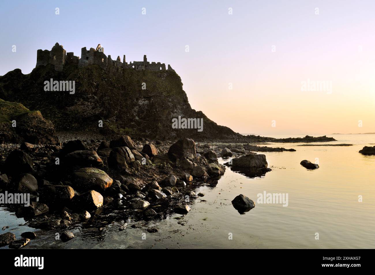Le Château de Dunluce, ruine médiévale entre Portrush et Bushmills. Au nord de la Côte d'Antrim Road, comté d'Antrim, en Irlande du Nord. Coucher du soleil Banque D'Images