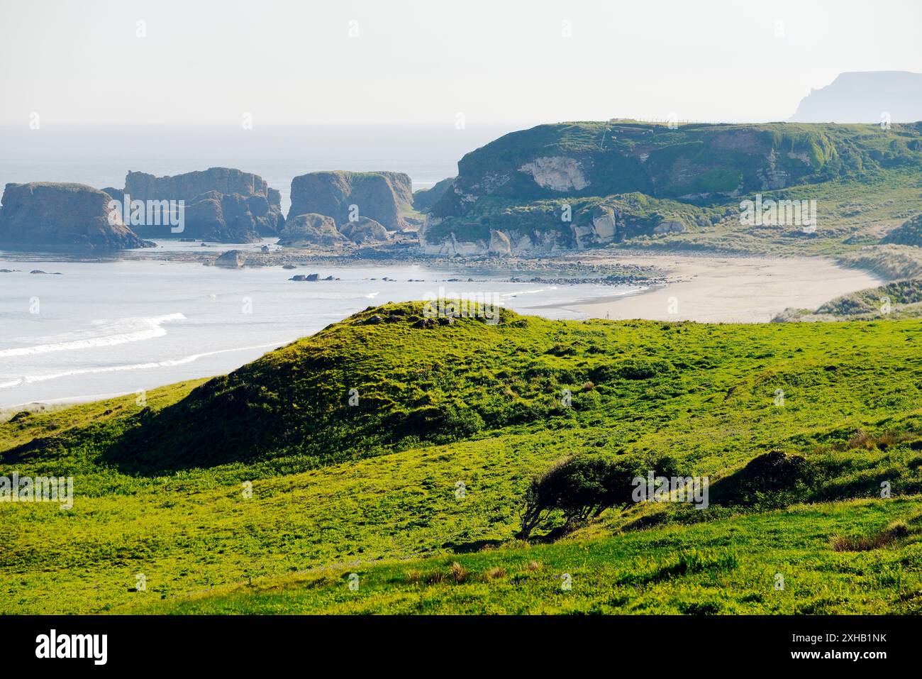 White Park Bay sur la côte nord d'Antrim, Irlande du Nord. Le monticule central dans les dunes de sable est un site de sépulture préhistorique avec des pierres de péristalith. On regarde N.E. Banque D'Images