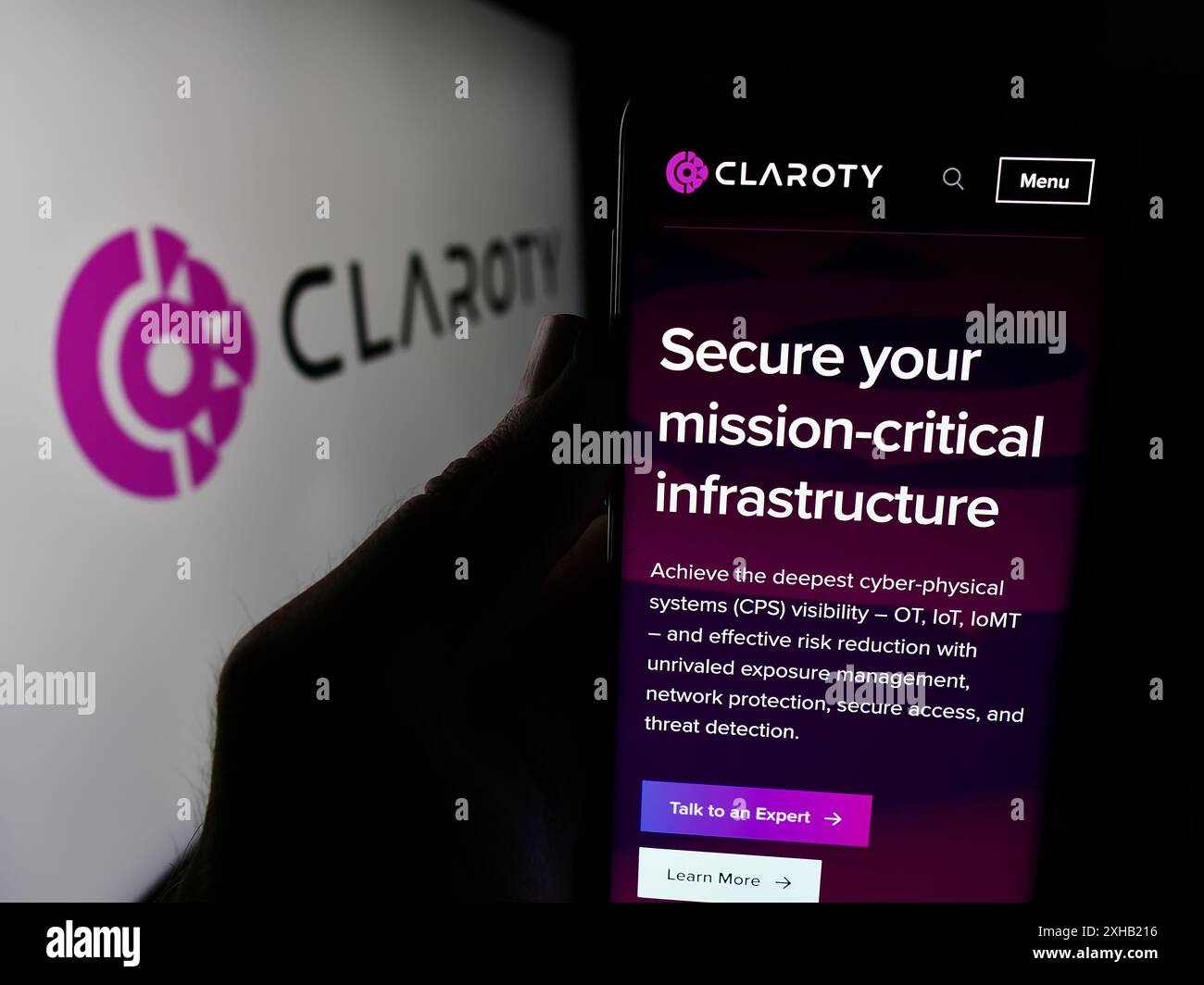 Personne tenant un smartphone avec le site Web de la société de cybersécurité Claroty Ltd devant le logo de l'entreprise. Concentrez-vous sur le centre de l'écran du téléphone. Banque D'Images