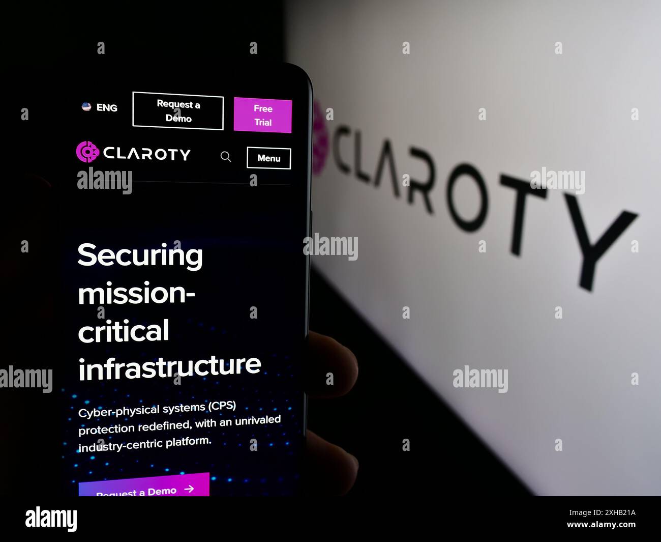 Personne tenant le téléphone portable avec la page Web de la société de cybersécurité Claroty Ltd devant le logo de l'entreprise. Concentrez-vous sur le centre de l'écran du téléphone. Banque D'Images