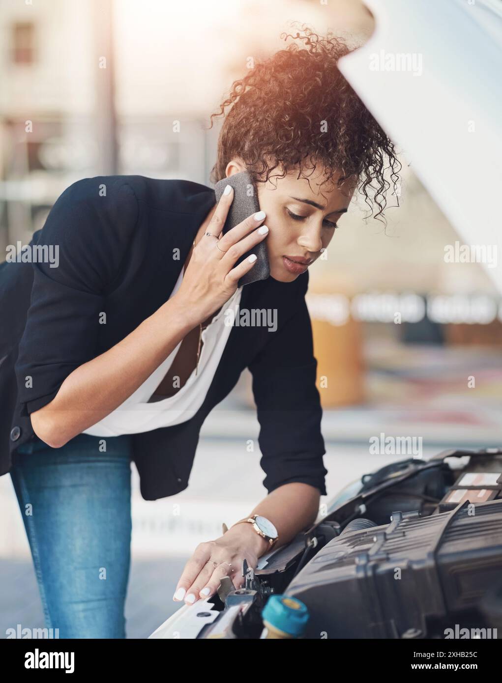 Femme, batterie et appel téléphonique pour problème de voiture ou parler à l'assistance routière pour le service automobile. Travailleur, trajet ou problème de puissance du moteur avec le véhicule Banque D'Images