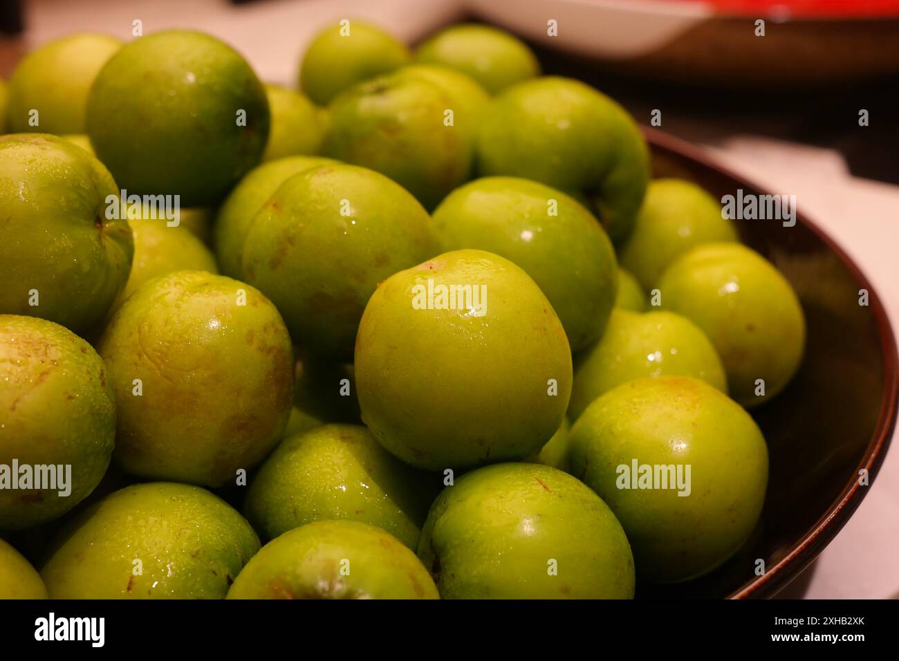 Prunes vertes dans un bol sur une table Banque D'Images