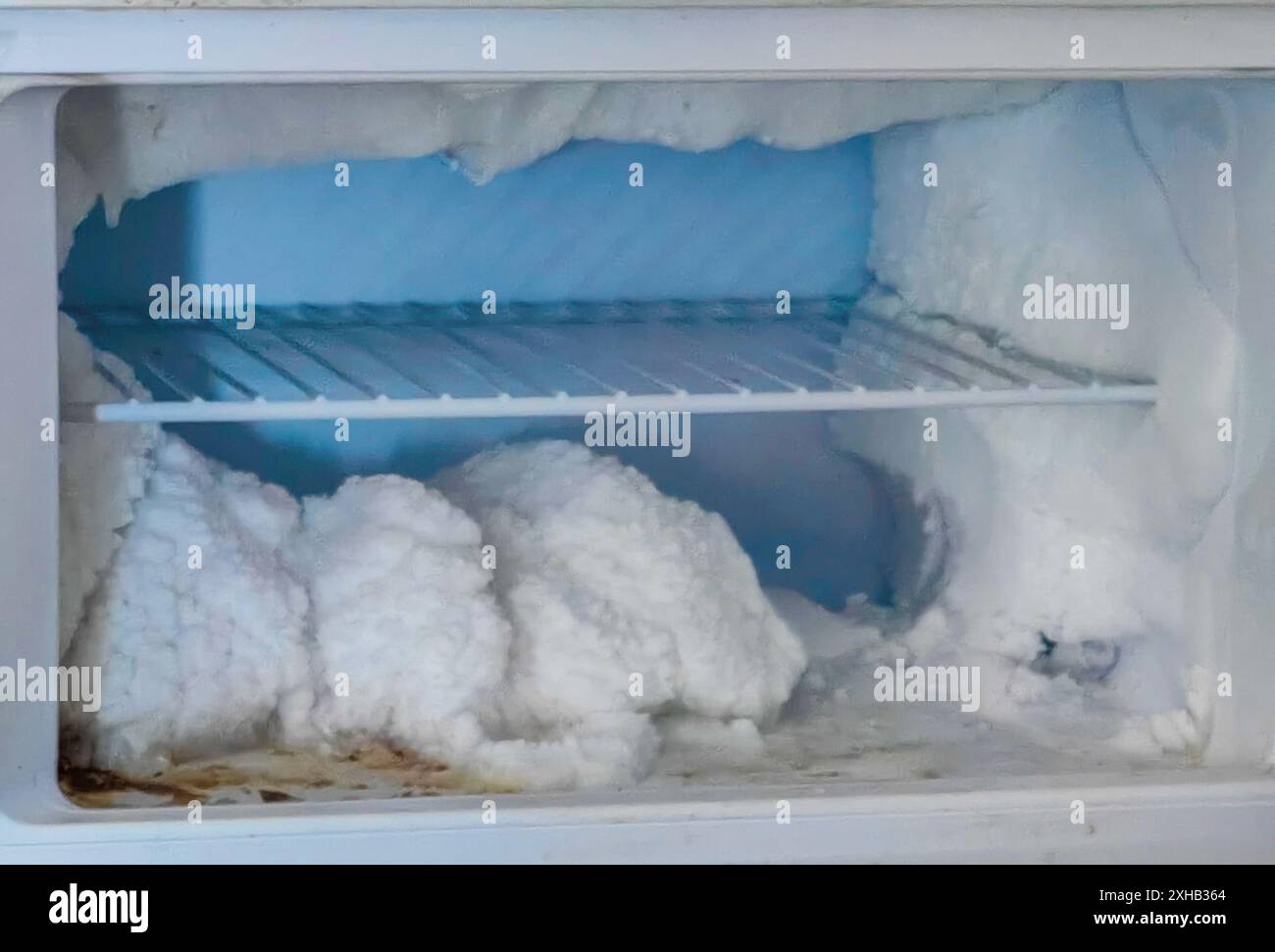 Frozen World : étagère couverte de glace dans la chambre froide d'un réfrigérateur vide Banque D'Images