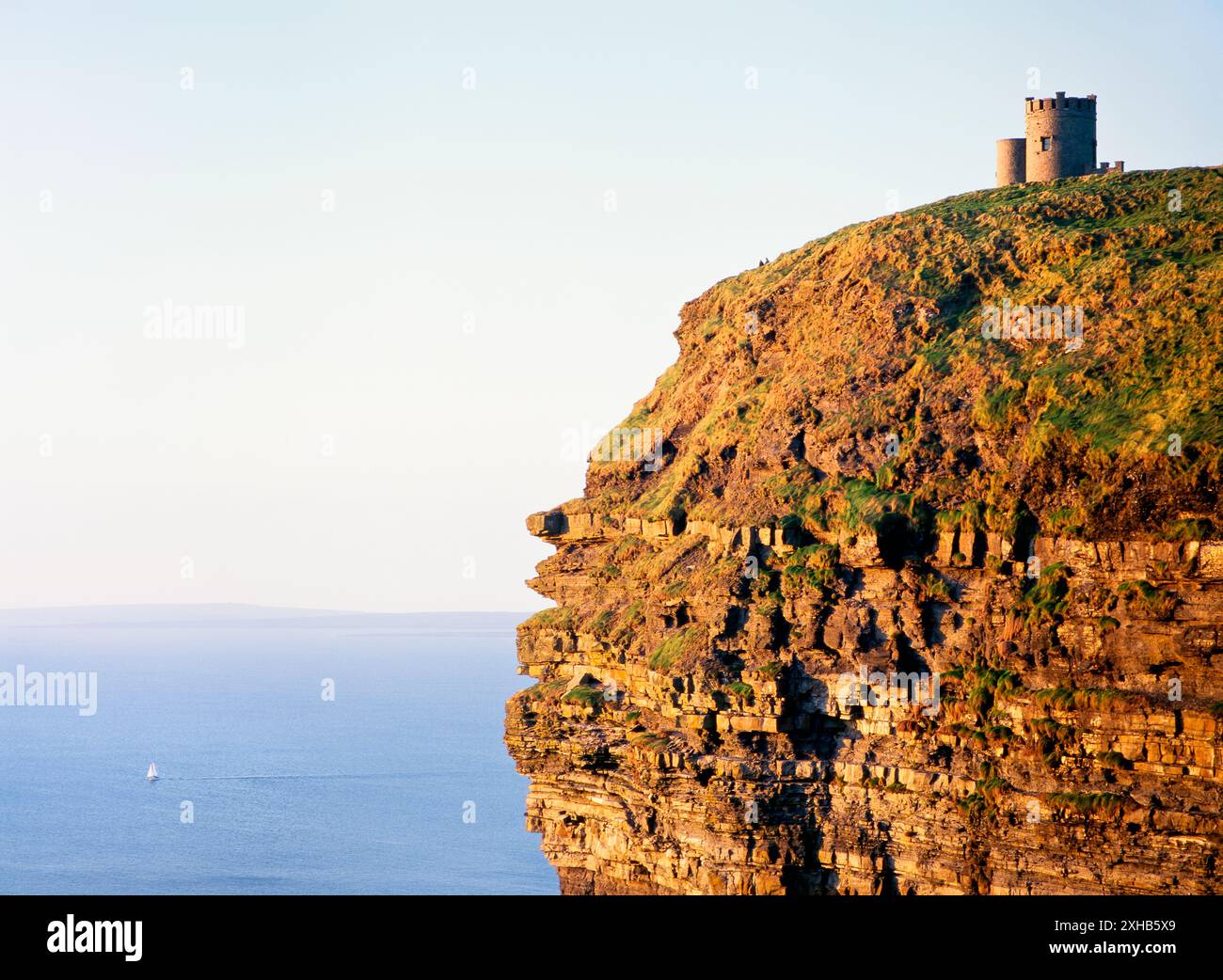 Tour O’Briens au sommet des falaises de Moher, comté de Clare, ouest de l’Irlande. Voilier yacht en distance. Océan Atlantique Banque D'Images