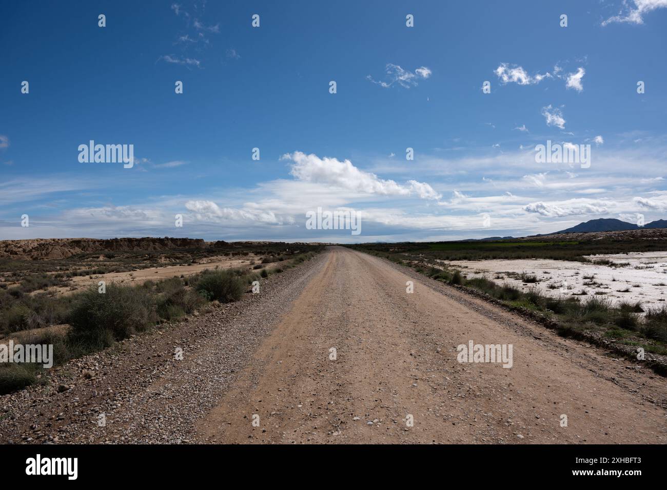 Beau paysage aride avec une route sablonneuse par une journée ensoleillée brillante. Nouveaux départs, désert et paysage montagneux. Banque D'Images