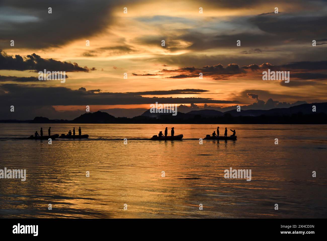 Bateaux du personnel de la Force d'intervention en cas de catastrophe de l'État (SDRF) passant par le fleuve Brahmapoutre lors d'un coucher de soleil, à Machkhowa à Guwahati le mercredi août Banque D'Images