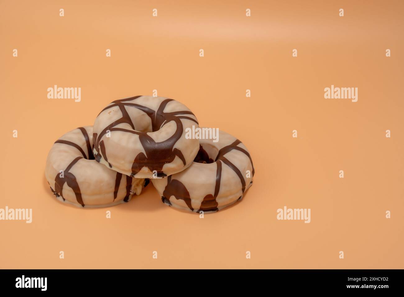 Trois beignets avec glaçage au chocolat sur le dessus. Les beignets sont empilés les uns sur les autres Banque D'Images