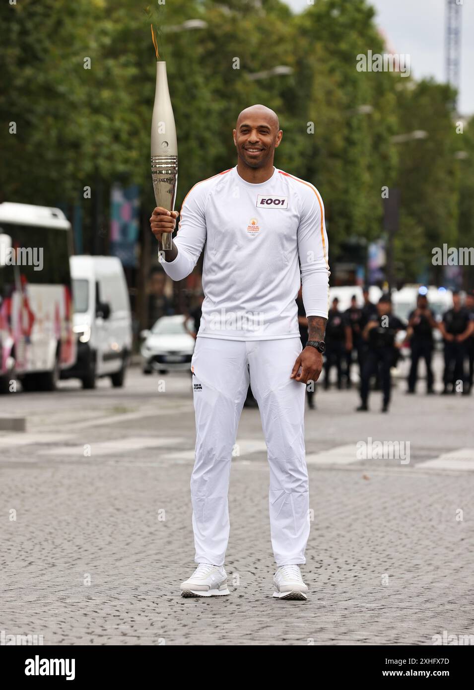 Paris, France. 14 juillet 2024. Thierry Henry, entraîneur des Jeux Olympiques de football français 2024, tient la flamme olympique lors du relais de la flamme des Jeux Olympiques Paris 2024 à Paris, France, le 14 juillet 2024. Crédit : Gao Jing/Xinhua/Alamy Live News Banque D'Images