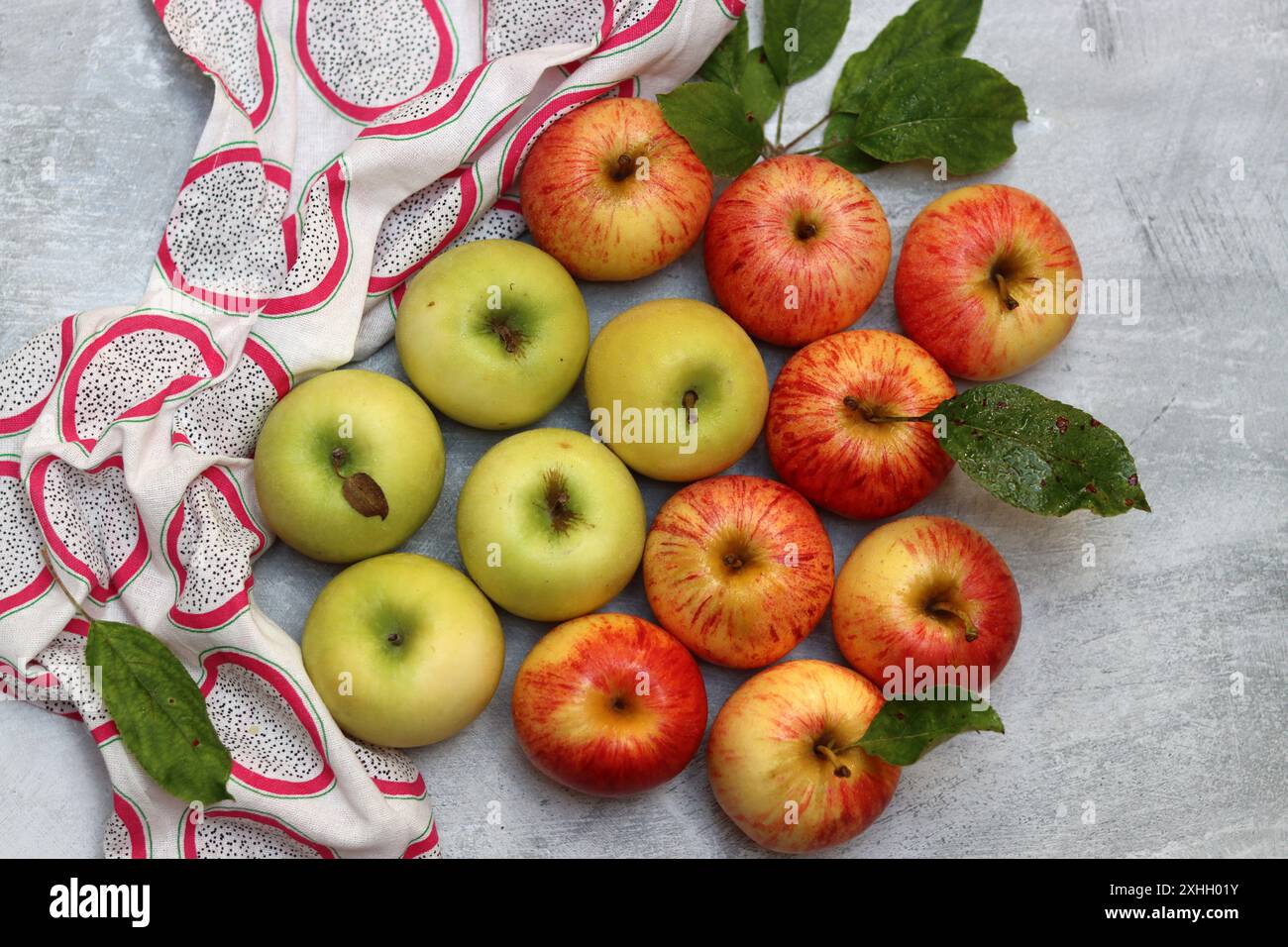 Belle photo de vue de dessus de pommes vertes et rouges. Fruit biologique juteux sur fond texturé gris clair avec espace pour le texte. Concept d'alimentation saine. Banque D'Images