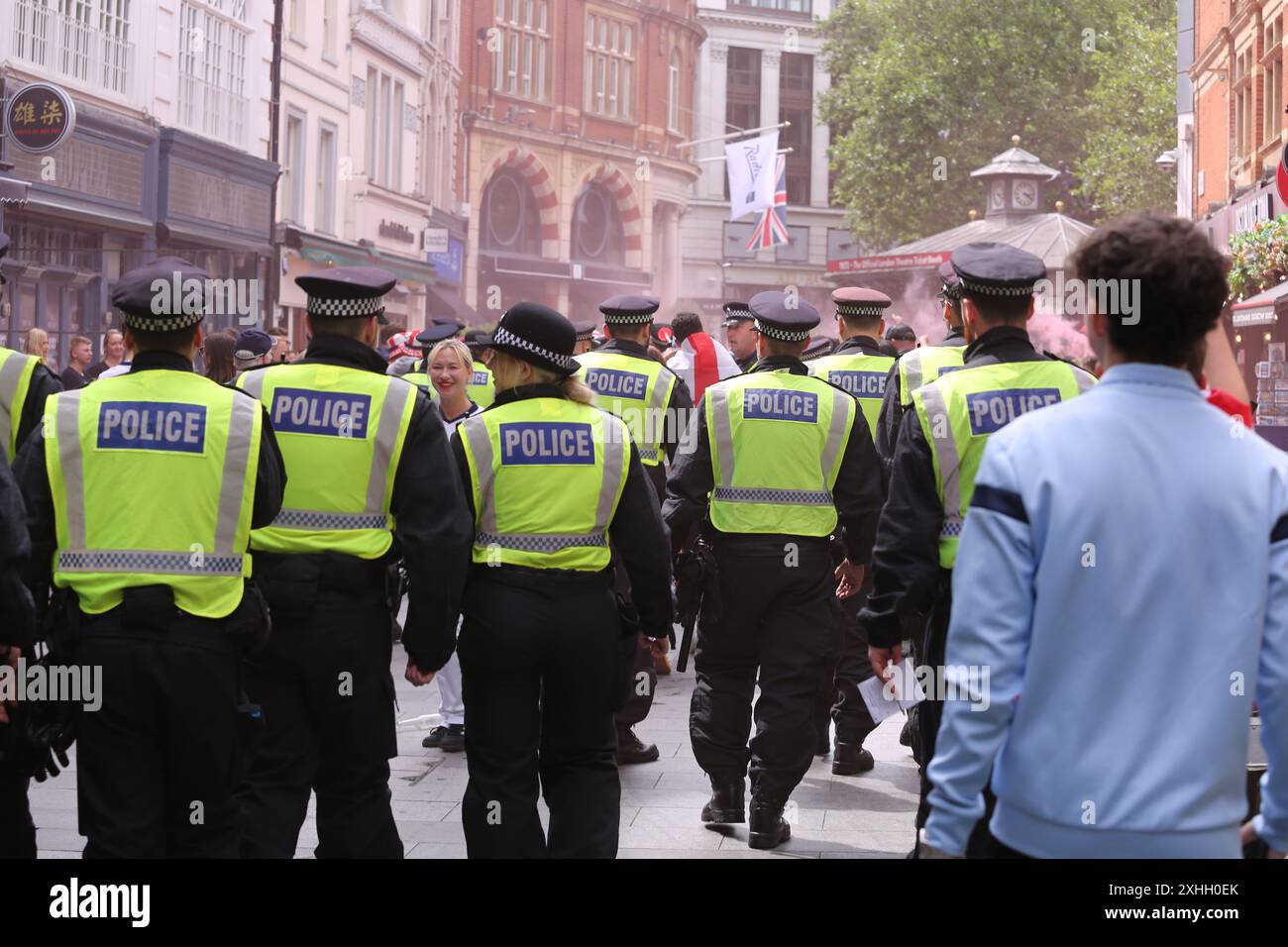 14 juillet 2024, Londres, UK police Control Boozy England fans dans le centre de Londres le jour de la finale Angleterre-Espagne de la Coupe d'Europe, les fans se rassemblent et prennent un verre dans le centre de Londres. Un groupe a été repoussé de la Charring Cross Road et enfermé à Leicester Square, et l'alcool a été confisqué en vertu des lois de Londres sur la consommation de boissons dans les rues. Crédit photo : Roland Ravenhill/Alamy Banque D'Images